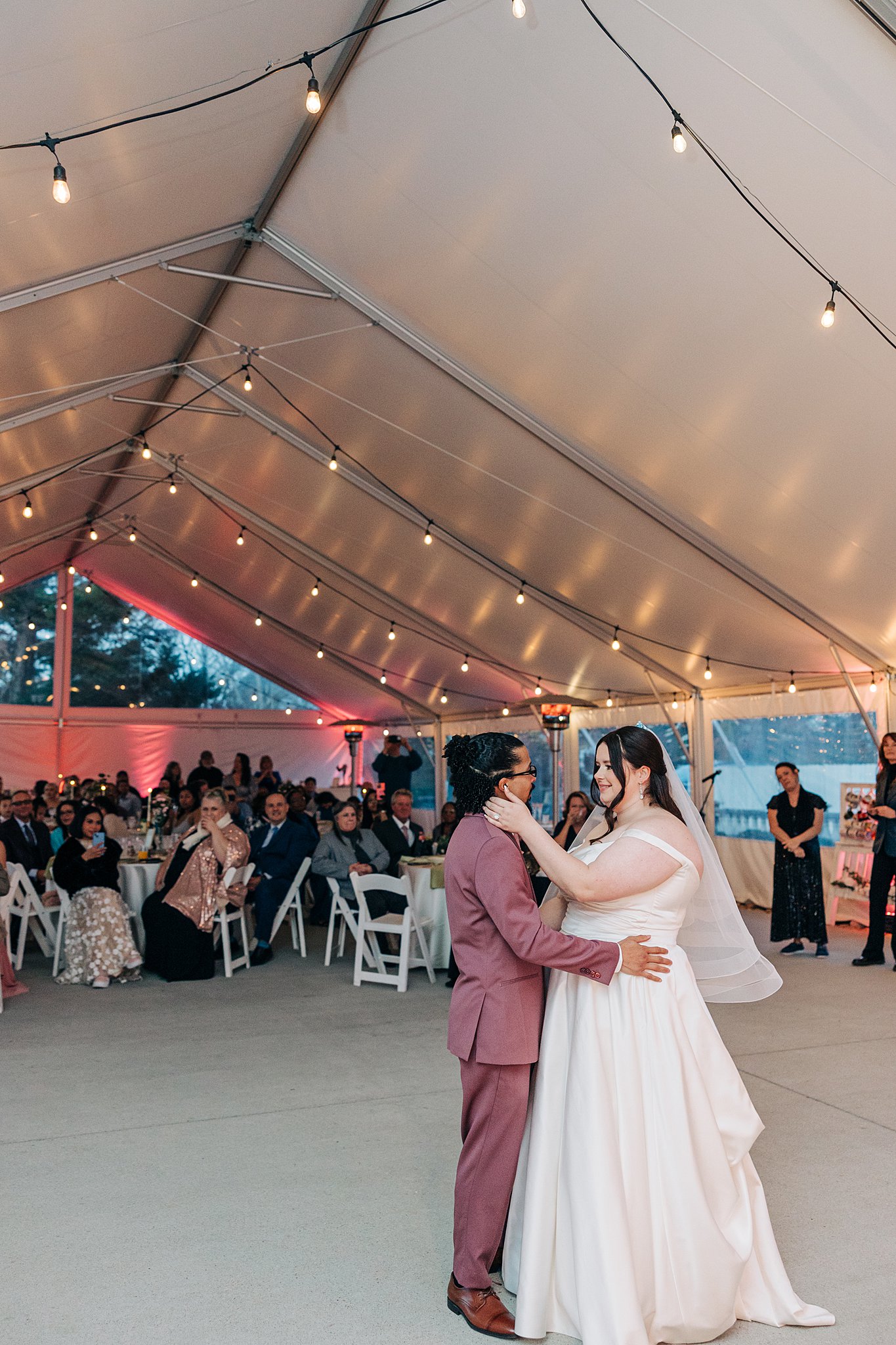 Newlyweds dance in front of their family under a large tent at their The Victorian: Youngsville wedding