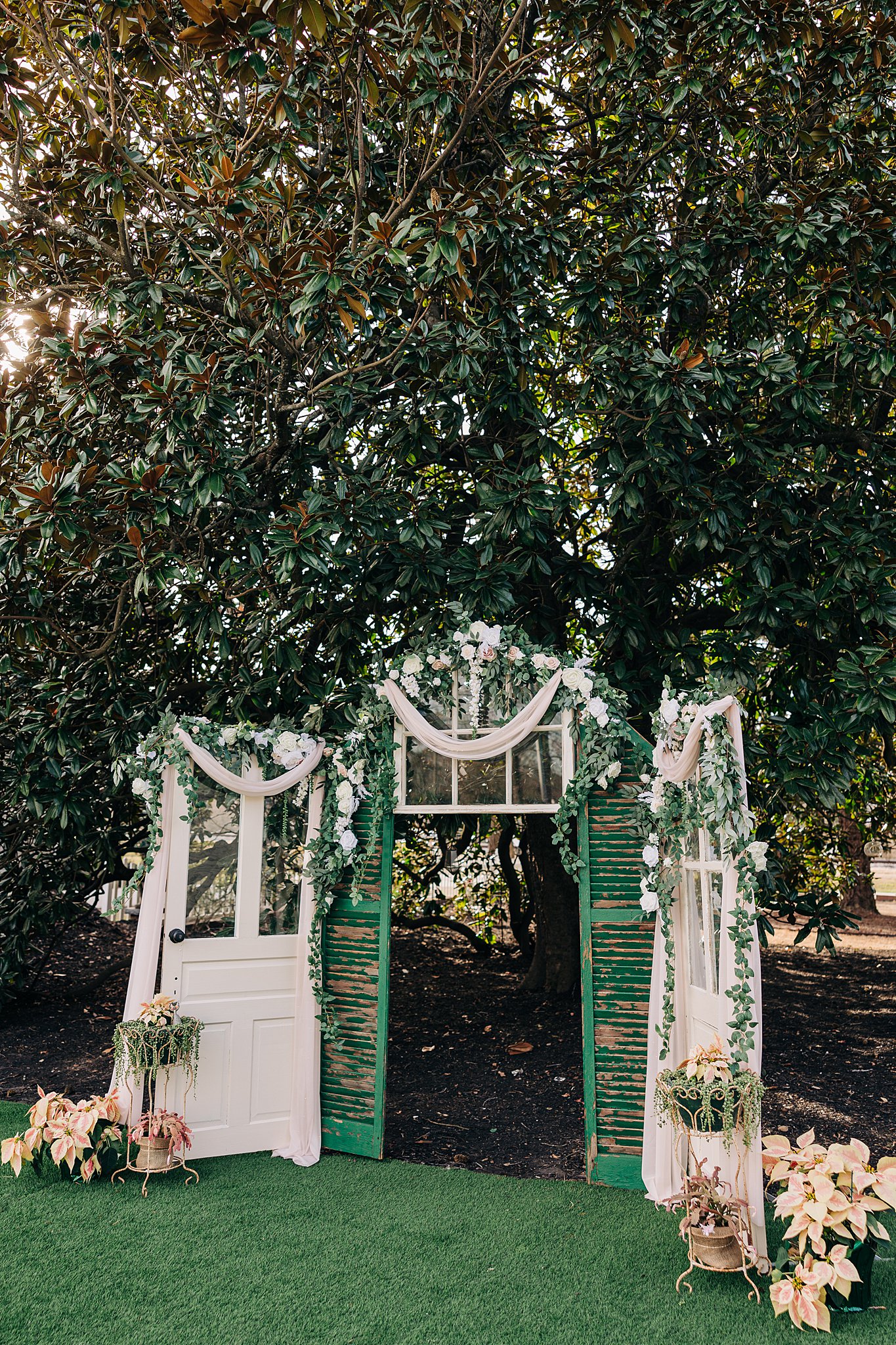 Details of a The Victorian: Youngsville wedding ceremony arbor with antique doors and flowers