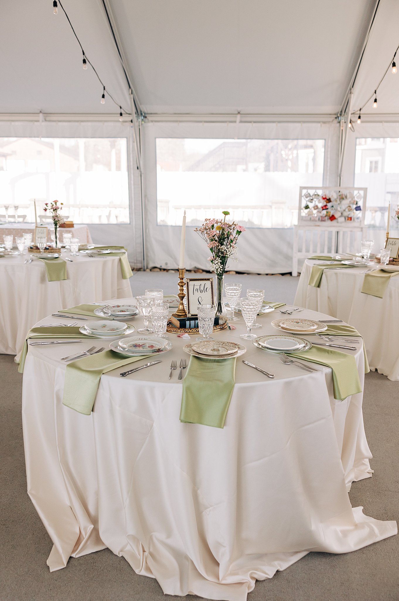 Details of a The Victorian: Youngsville wedding reception set up under a tent with green napkins