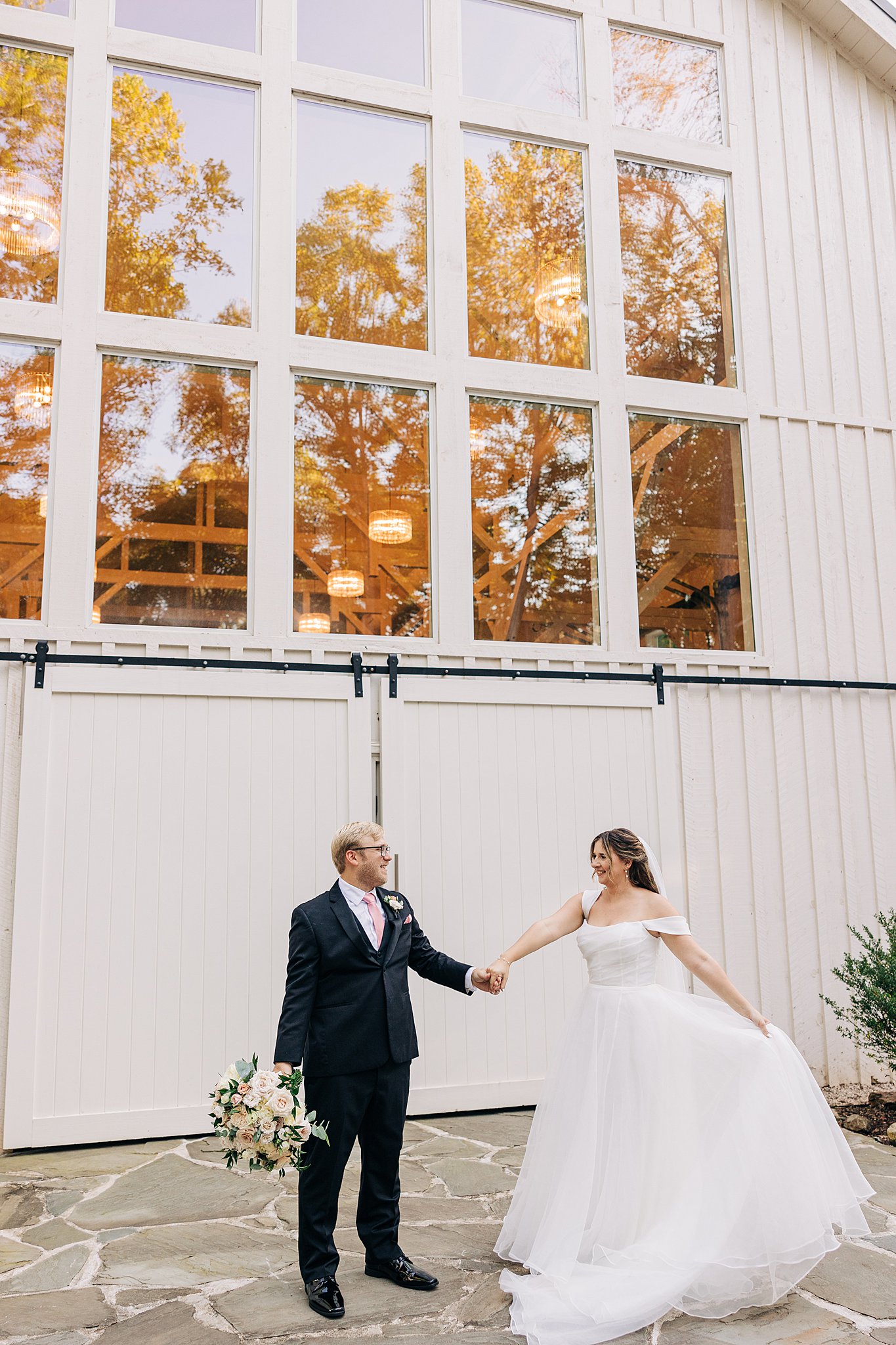 Newlyweds dance outside the main entrance barn doors at the carolina grove wedding venue