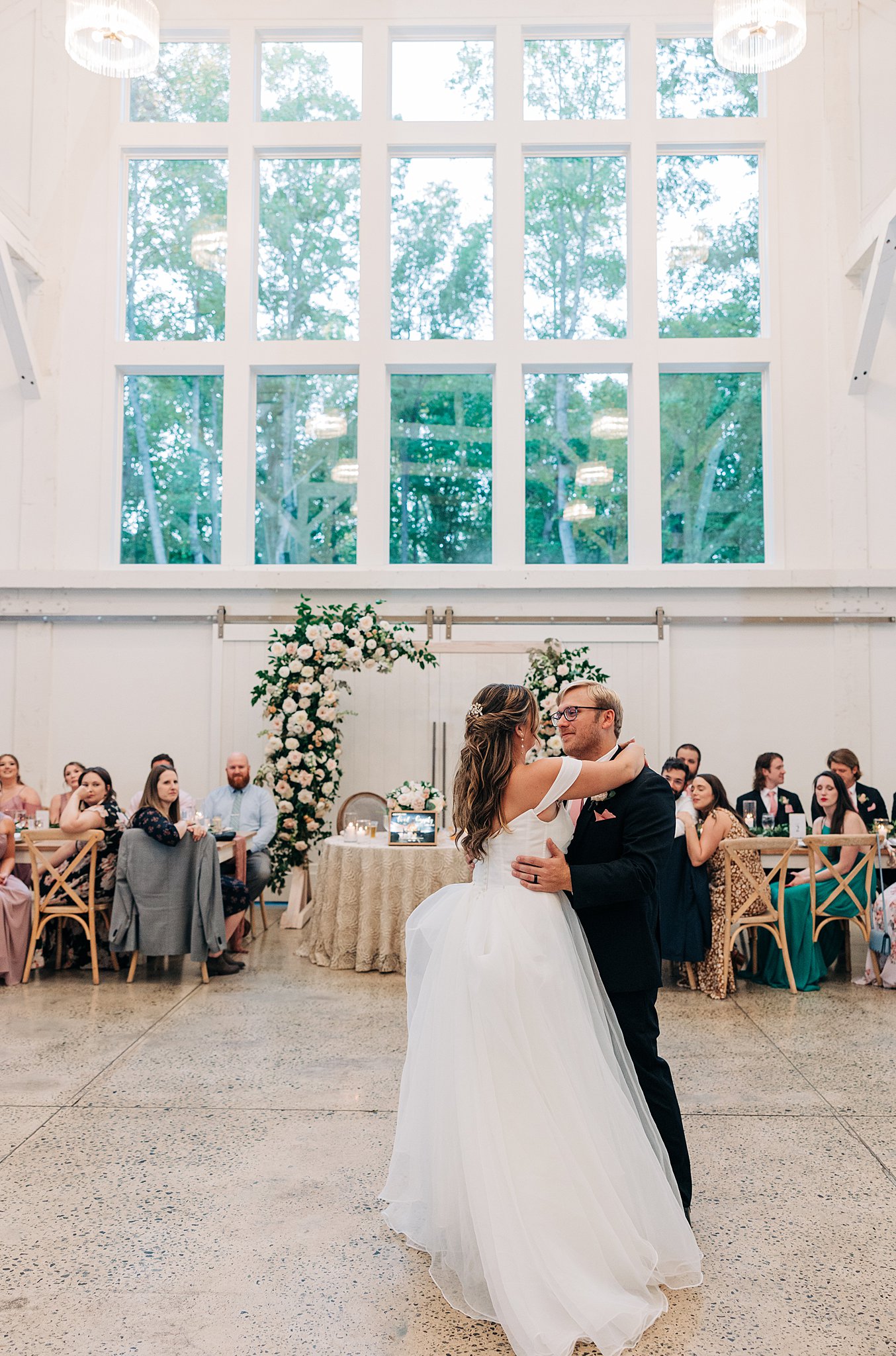Newlyweds dance on the dance floor for the first time surrounded by guests at their carolina grove wedding venue