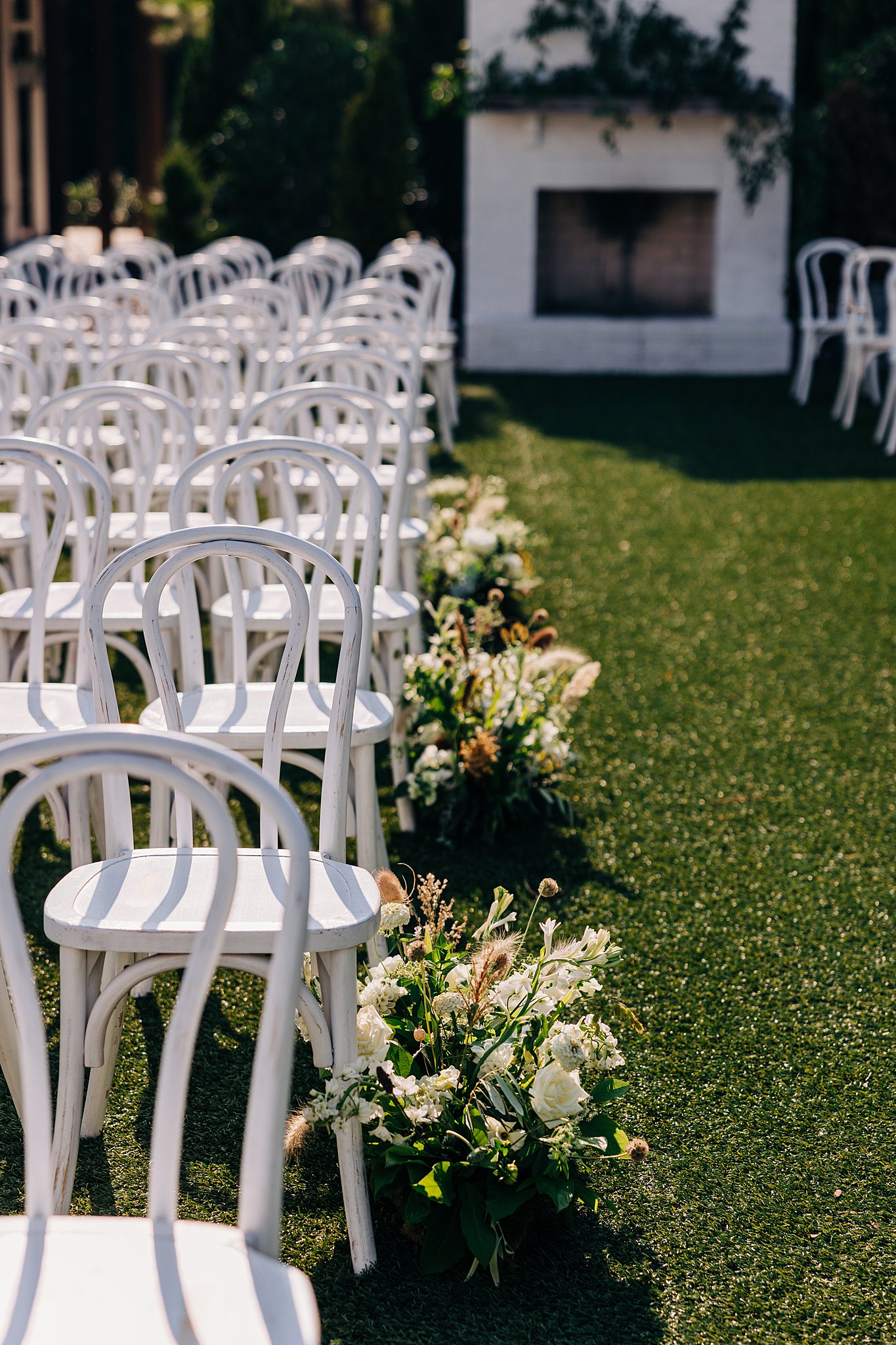 Details of a wedding reception set up on a lawn with flowers and white chairs at the bradford wedding venue