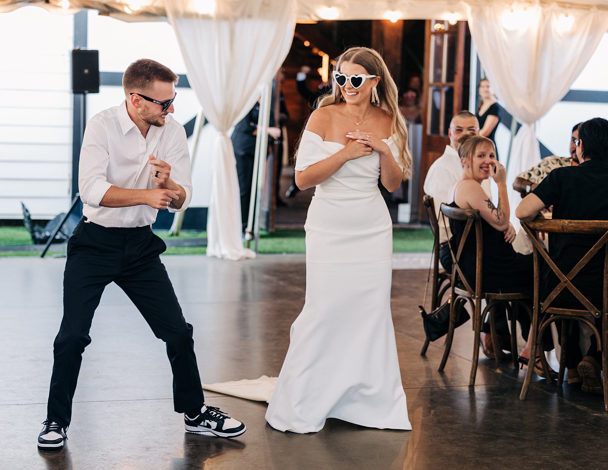 Newlyweds dance and laugh while entering their Summerfield Farms wedding reception dance floor