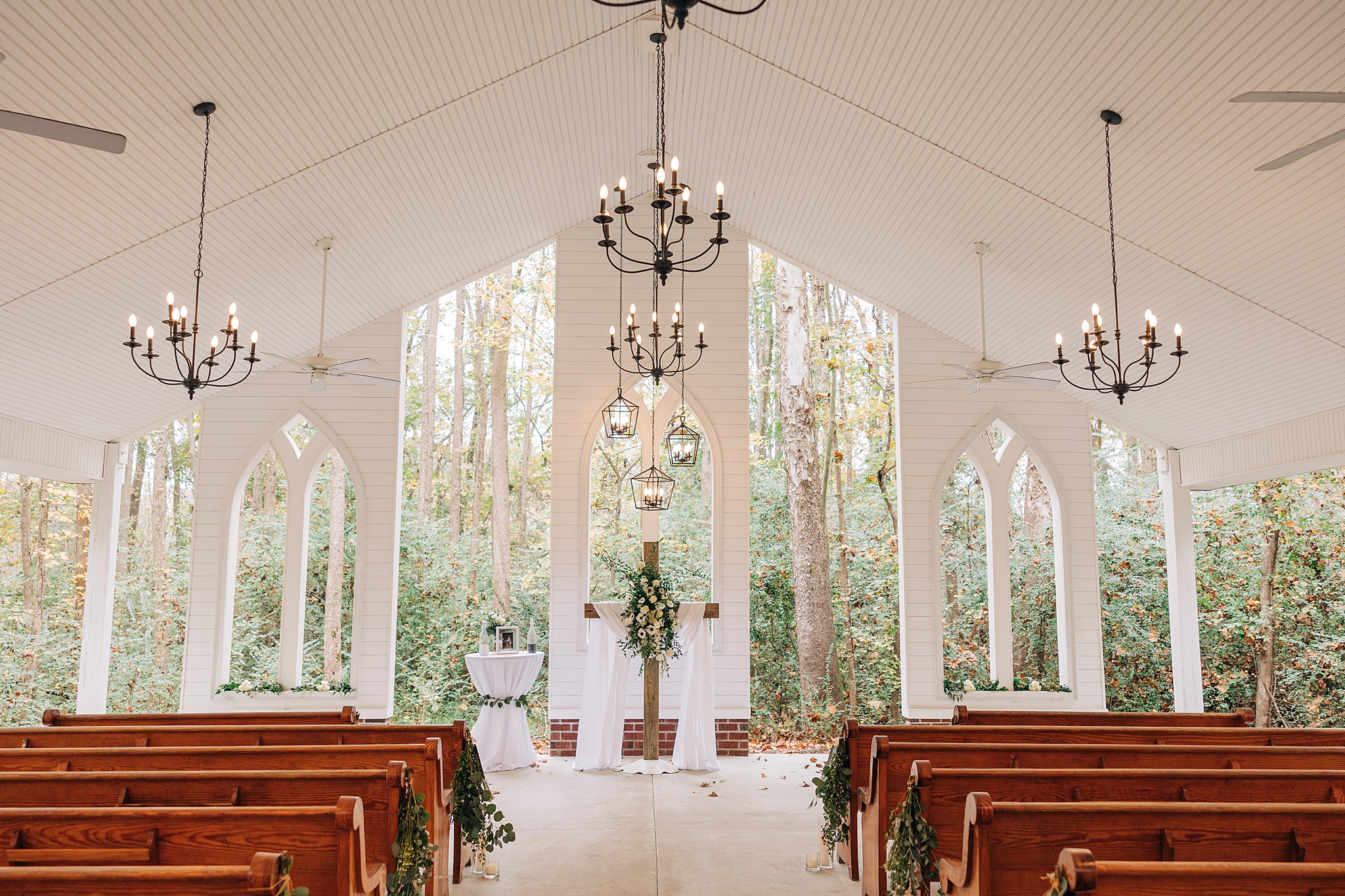 A view inside the open air cornealius properties wedding chapel set up for a ceremony with a wooden cross