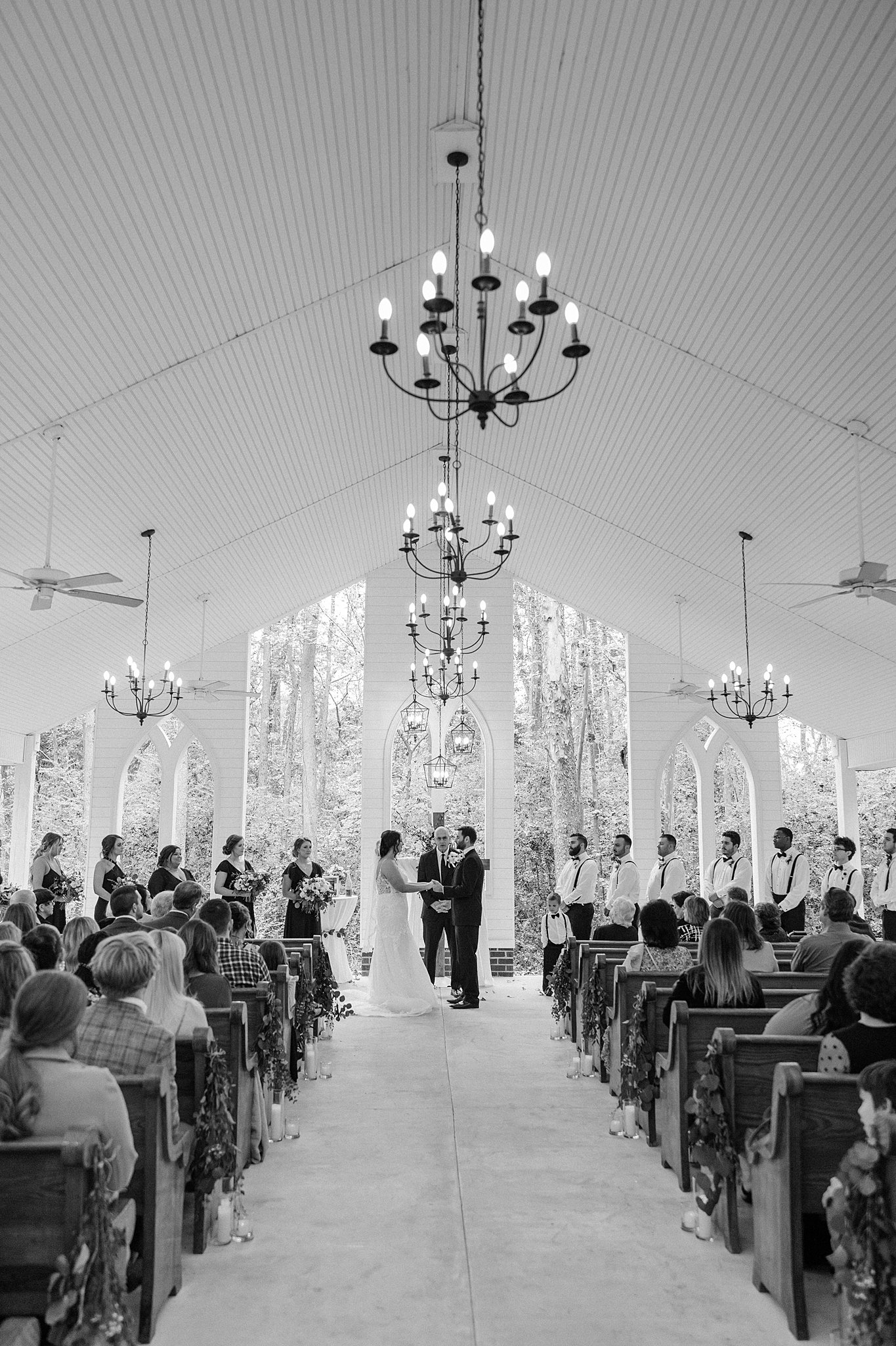 A black and white view of a wedding ceremony in an open air chapel
