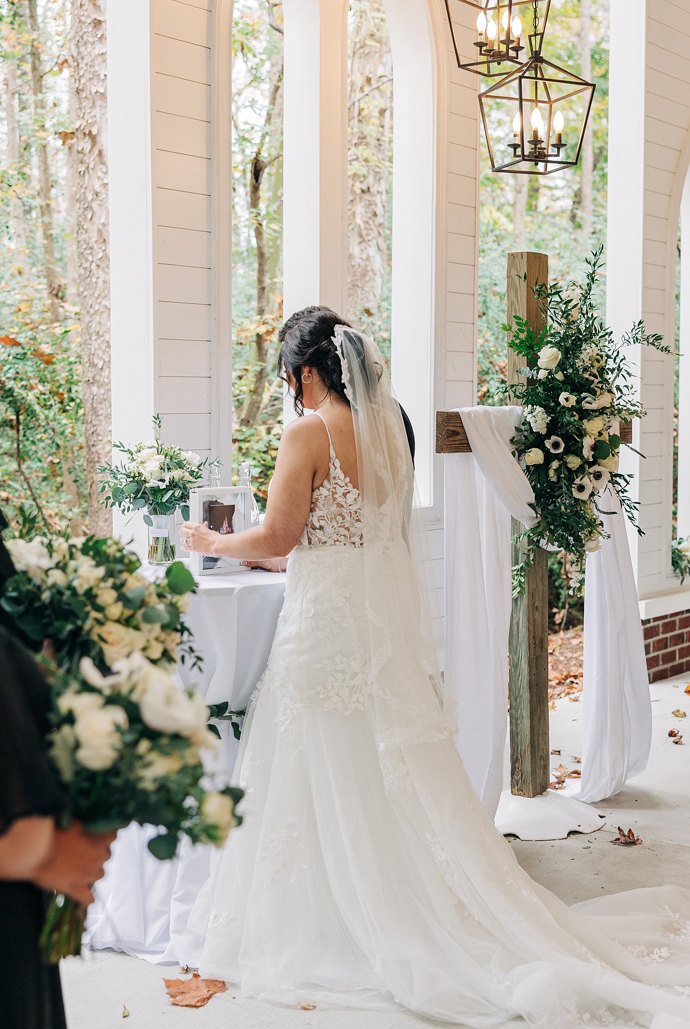 A bride adjusts details of her wedding ceremony set up on the altar