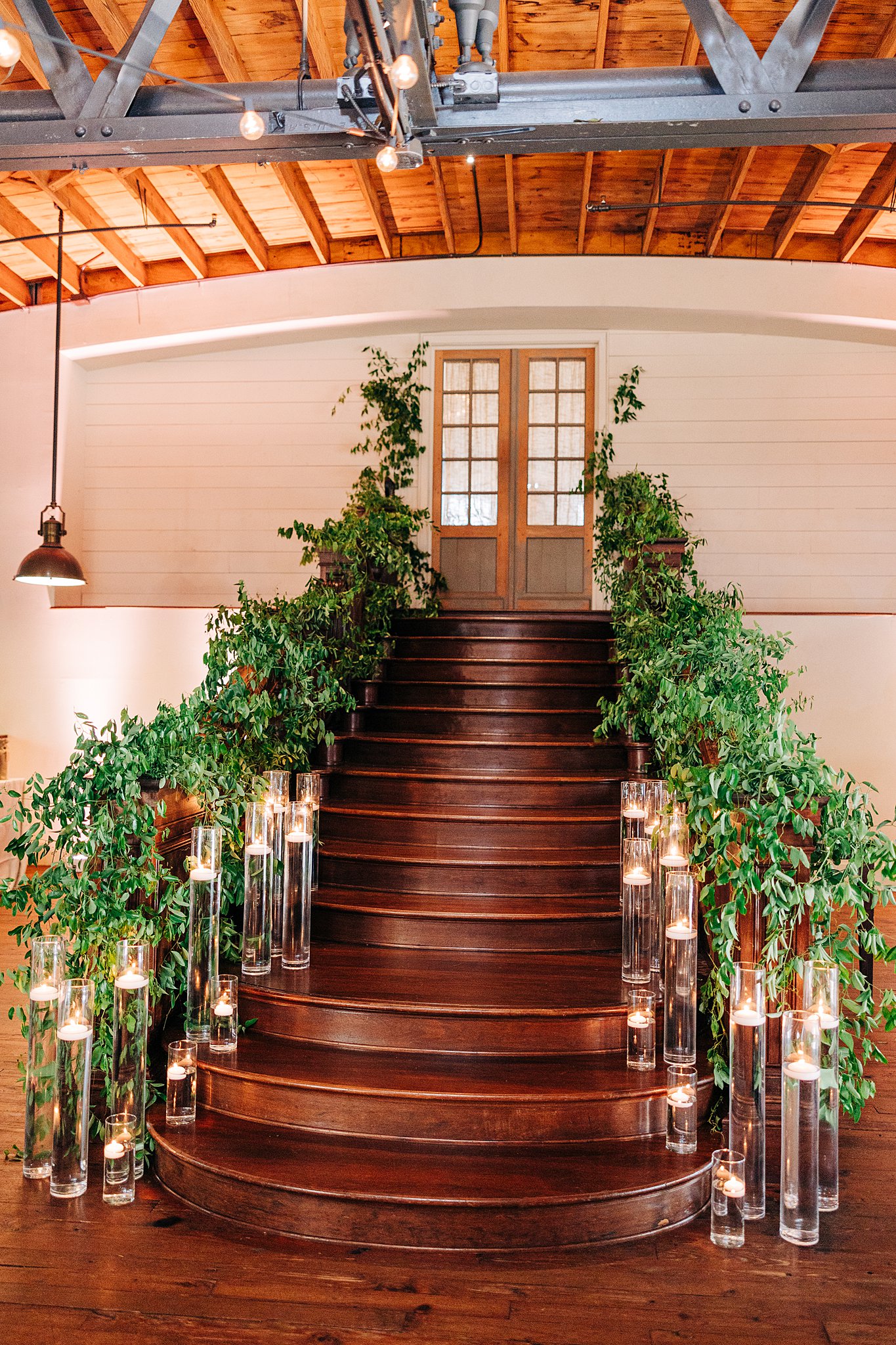 Details of the summerour studio wedding ceremony entrance staircase lines in greenery and candles