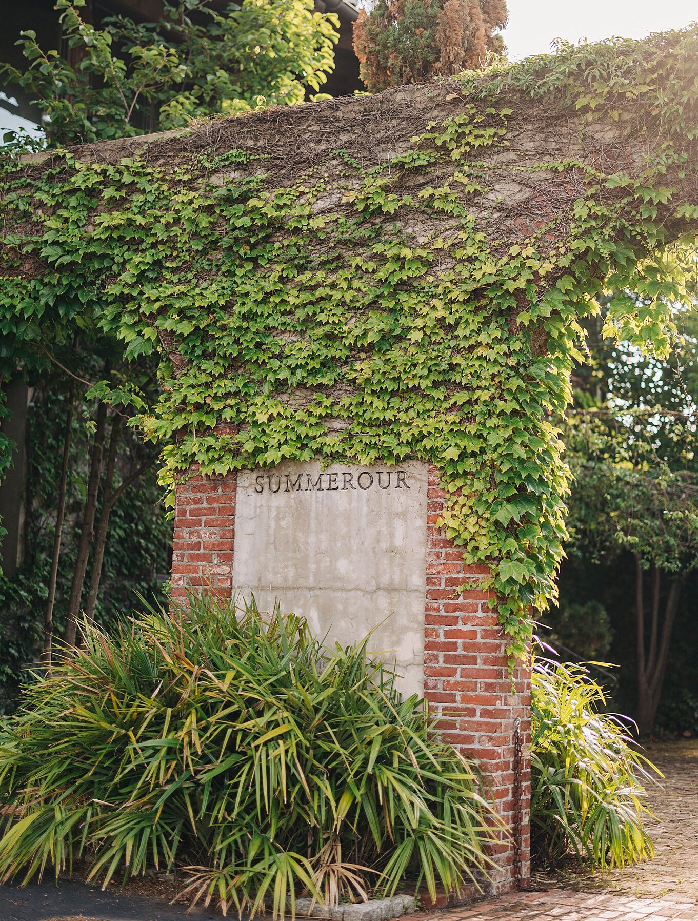 Details of the front entrance sign of the summerour studio wedding venue covered in ivy