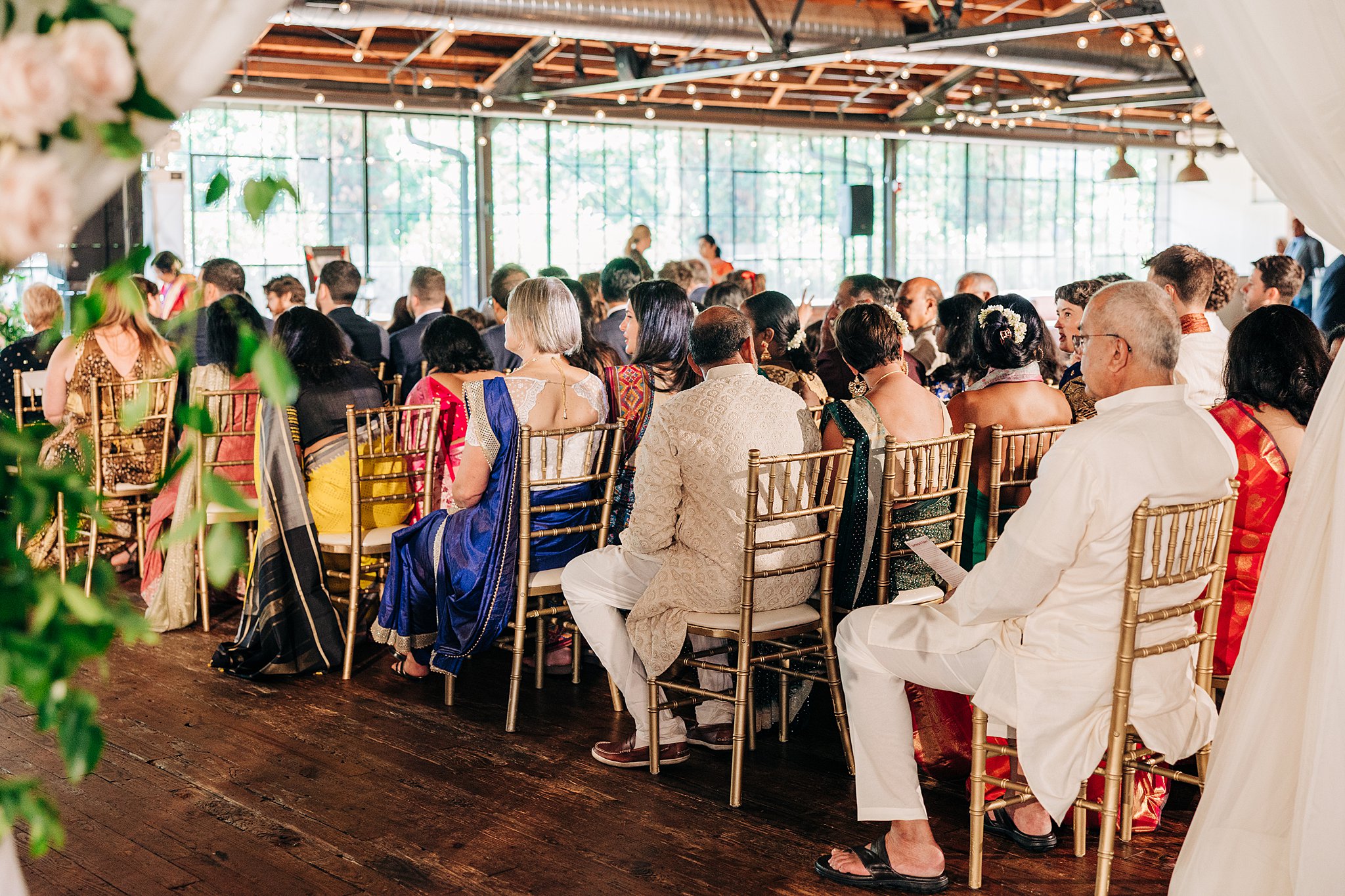 Guests during a summerour studio wedding reception indoors on gold chairs