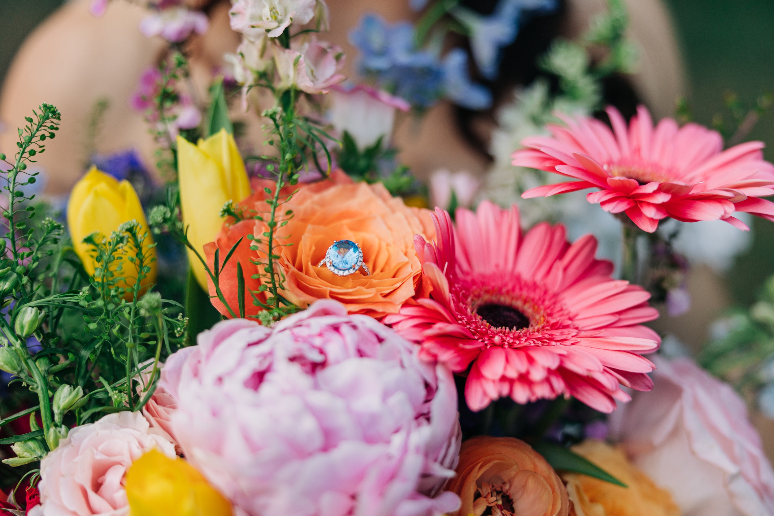 Details of a blue wedding ring in a vibrant bouquet