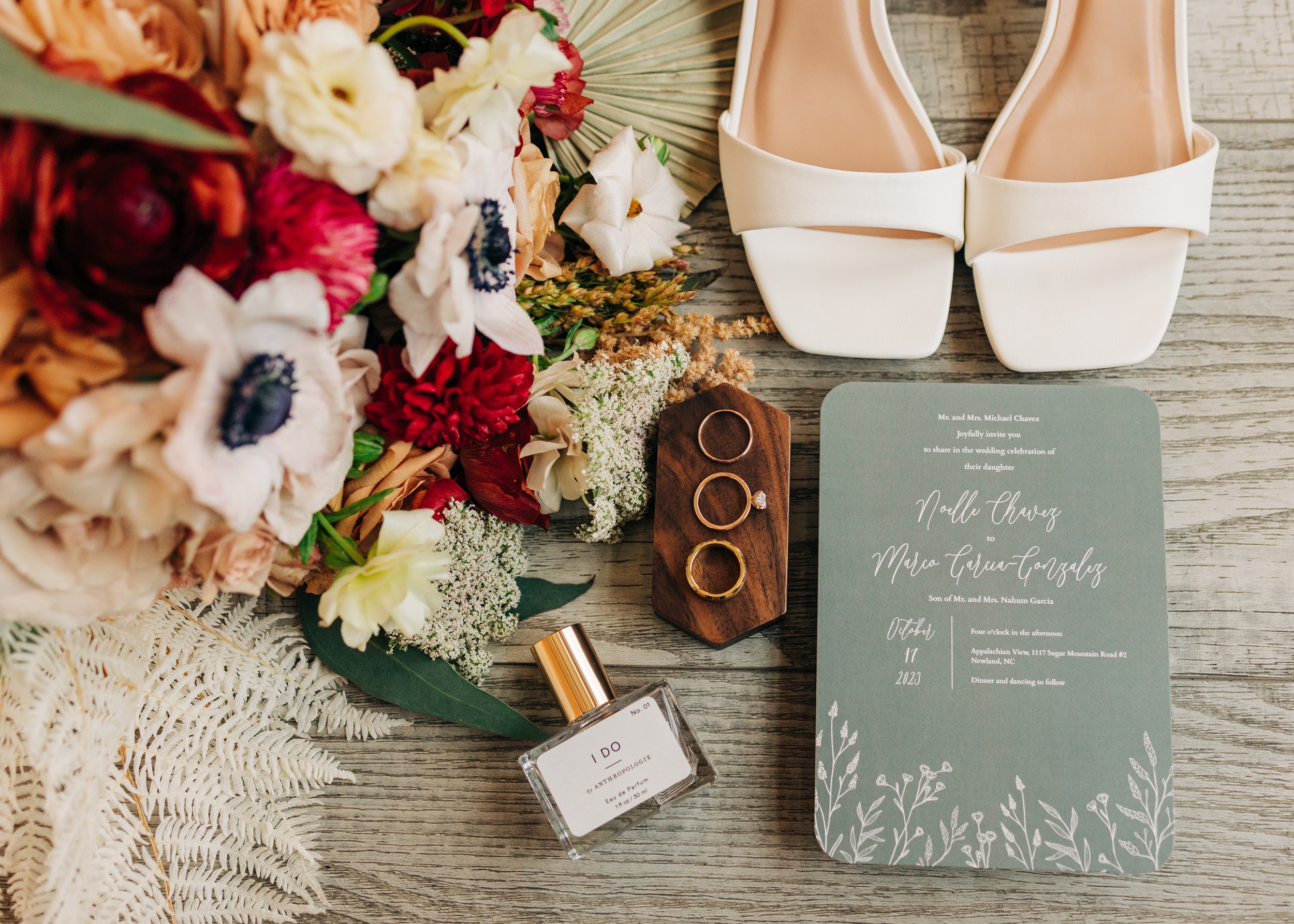 Details of wedding rings and bridal details on a wooden floor