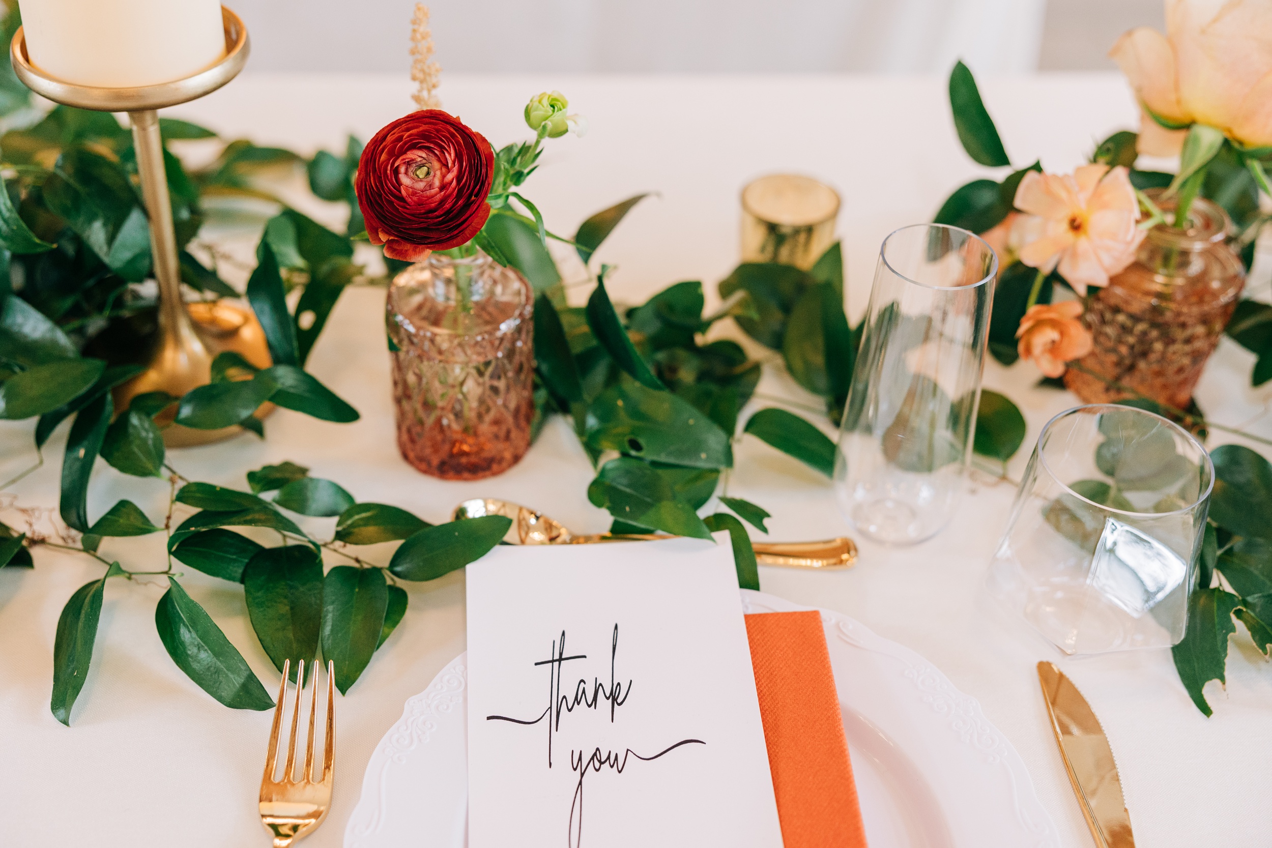 Details of an appalachian view wedding reception table setting with thank you card and gold silverware