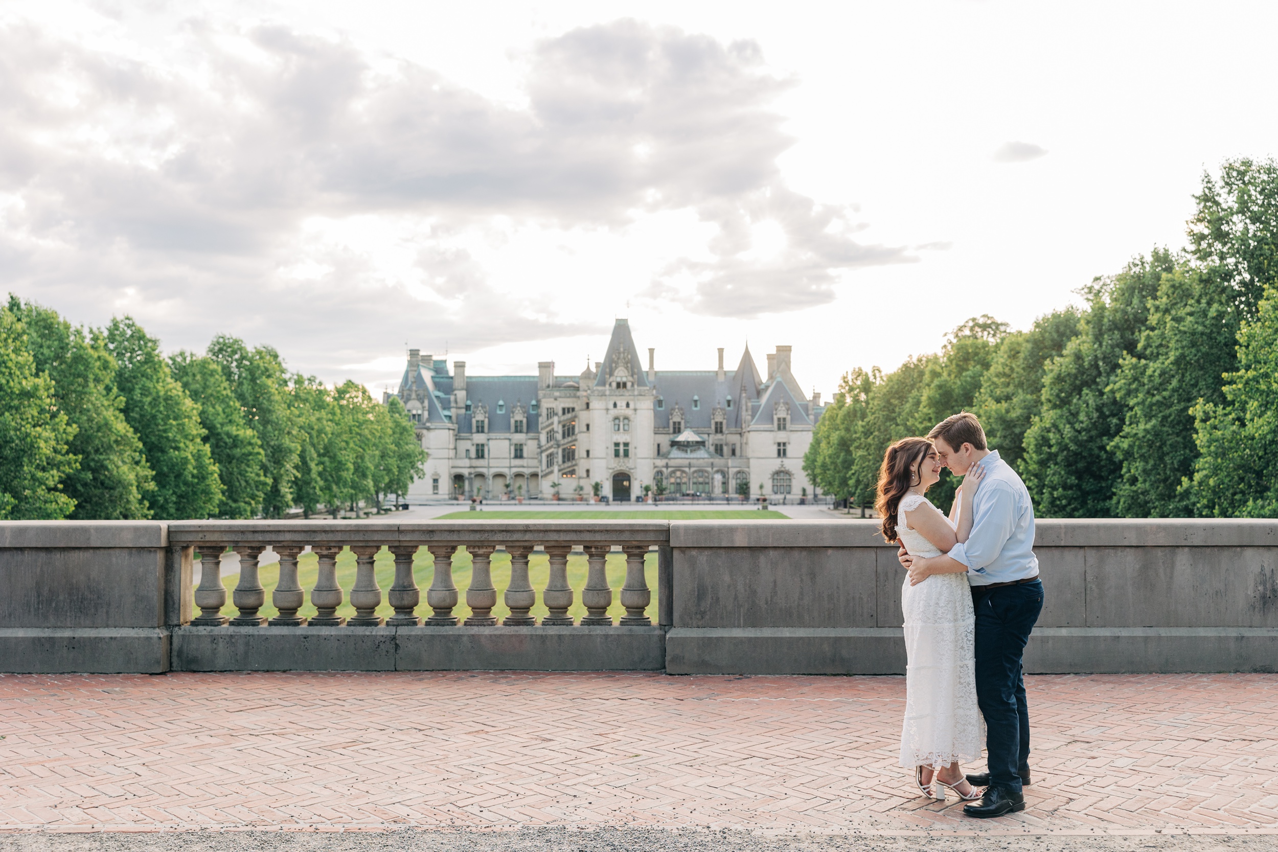 Newlyweds lean in for an intimate kiss with the biltmore estate wedding venue as their backdrop