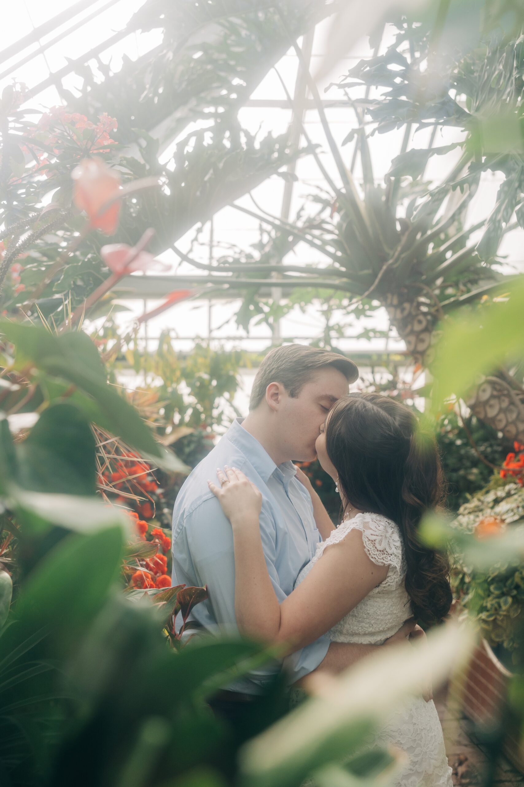 Newlyweds kiss in a tropical greenhouse garden at their biltmore estate wedding