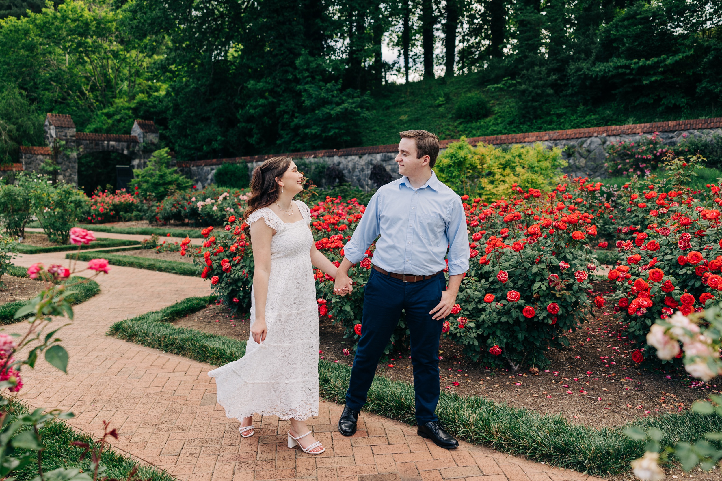 Newlyweds laugh while holding hands and walking in the gardens at their biltmore estate wedding