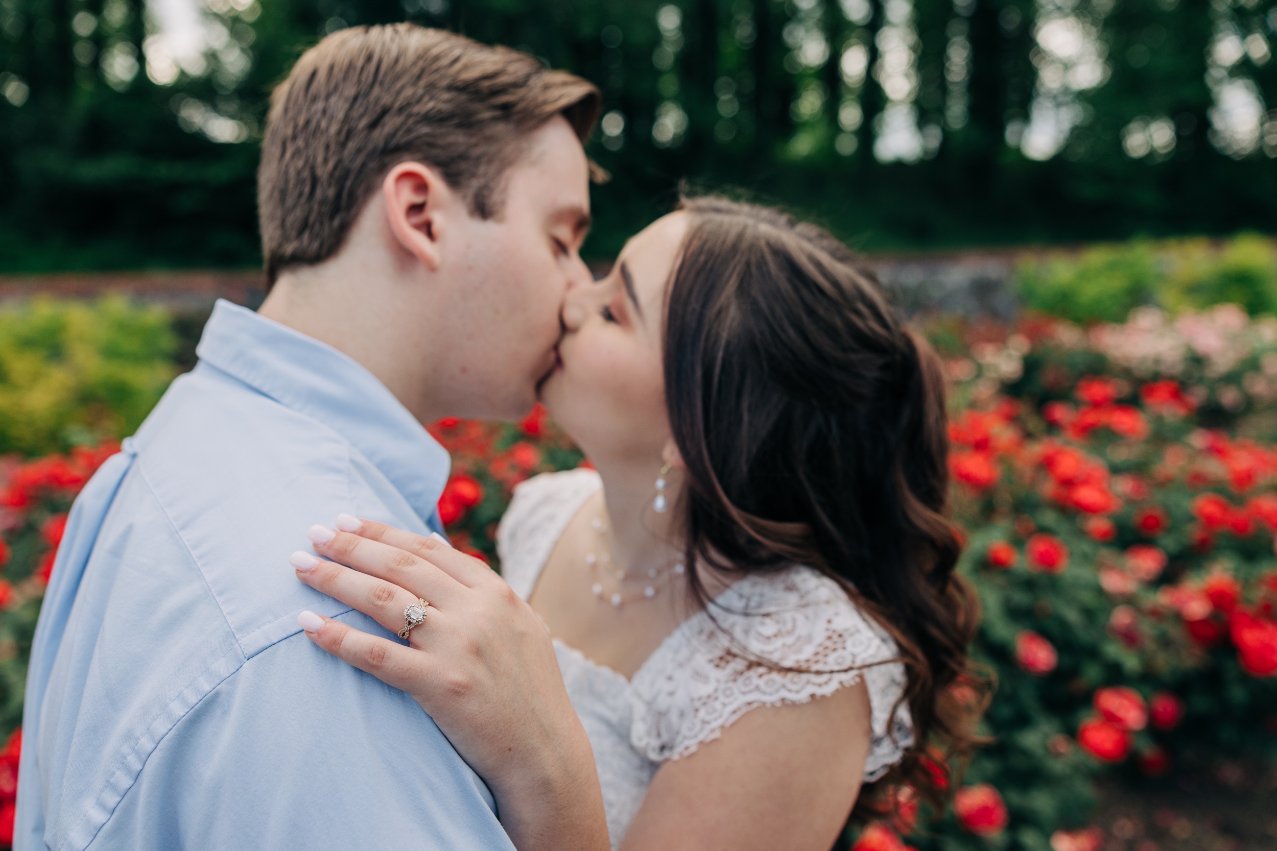 A bride and groom kiss while in a flower garden