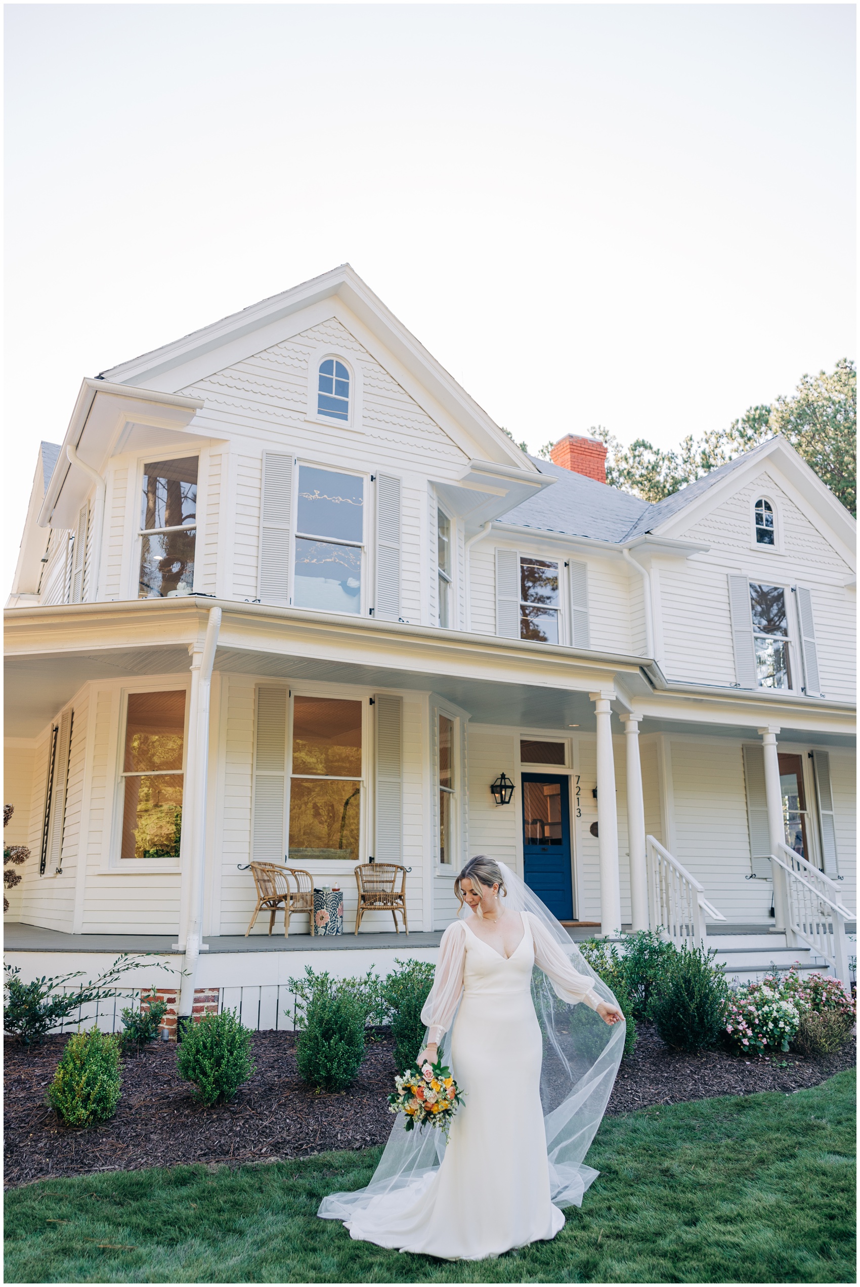 A bride walks through the lawn of the upchurch wedding venue outside the house