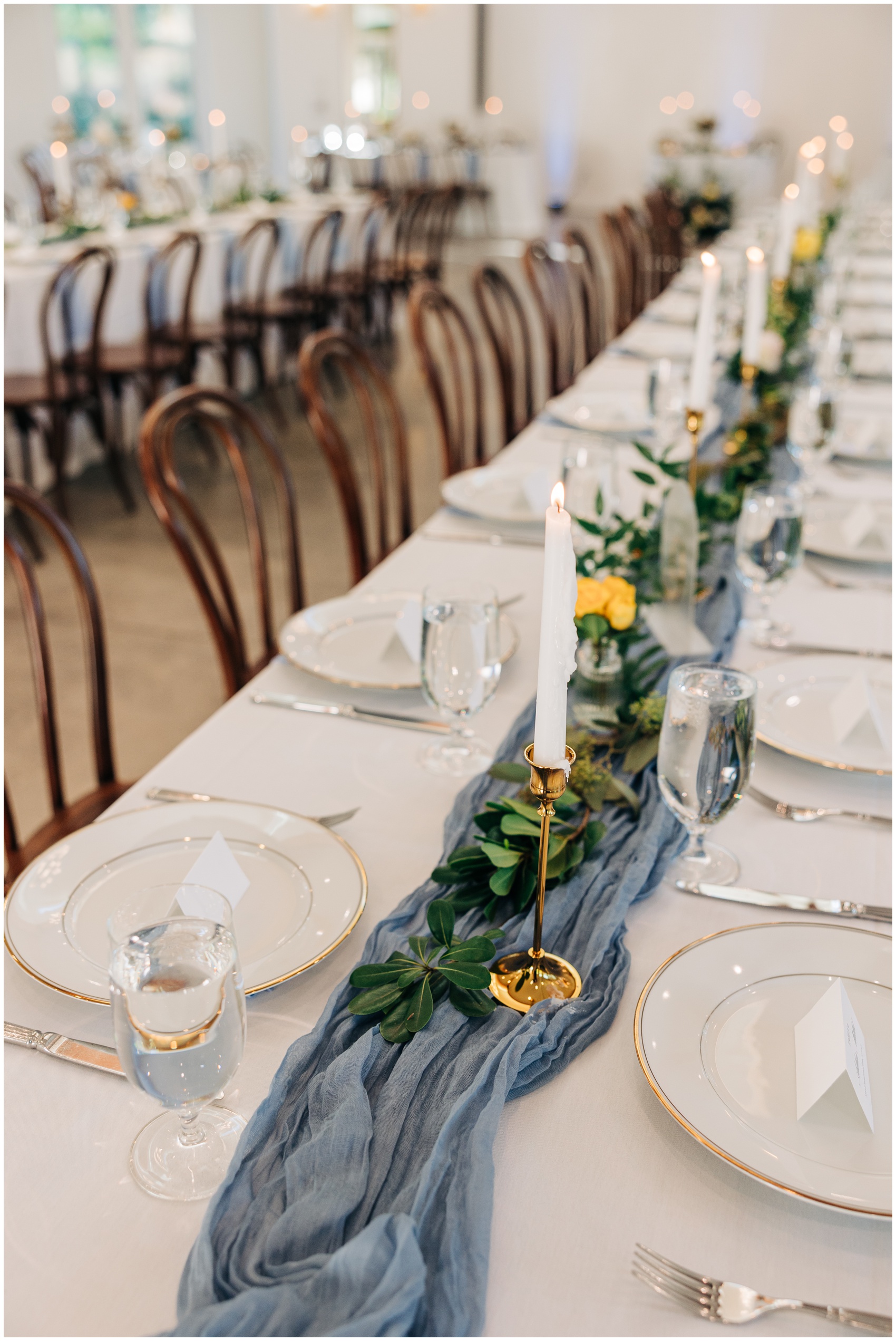 Deetails of a long table set up for a reception at the upchurch wedding venue with blue linen running the center