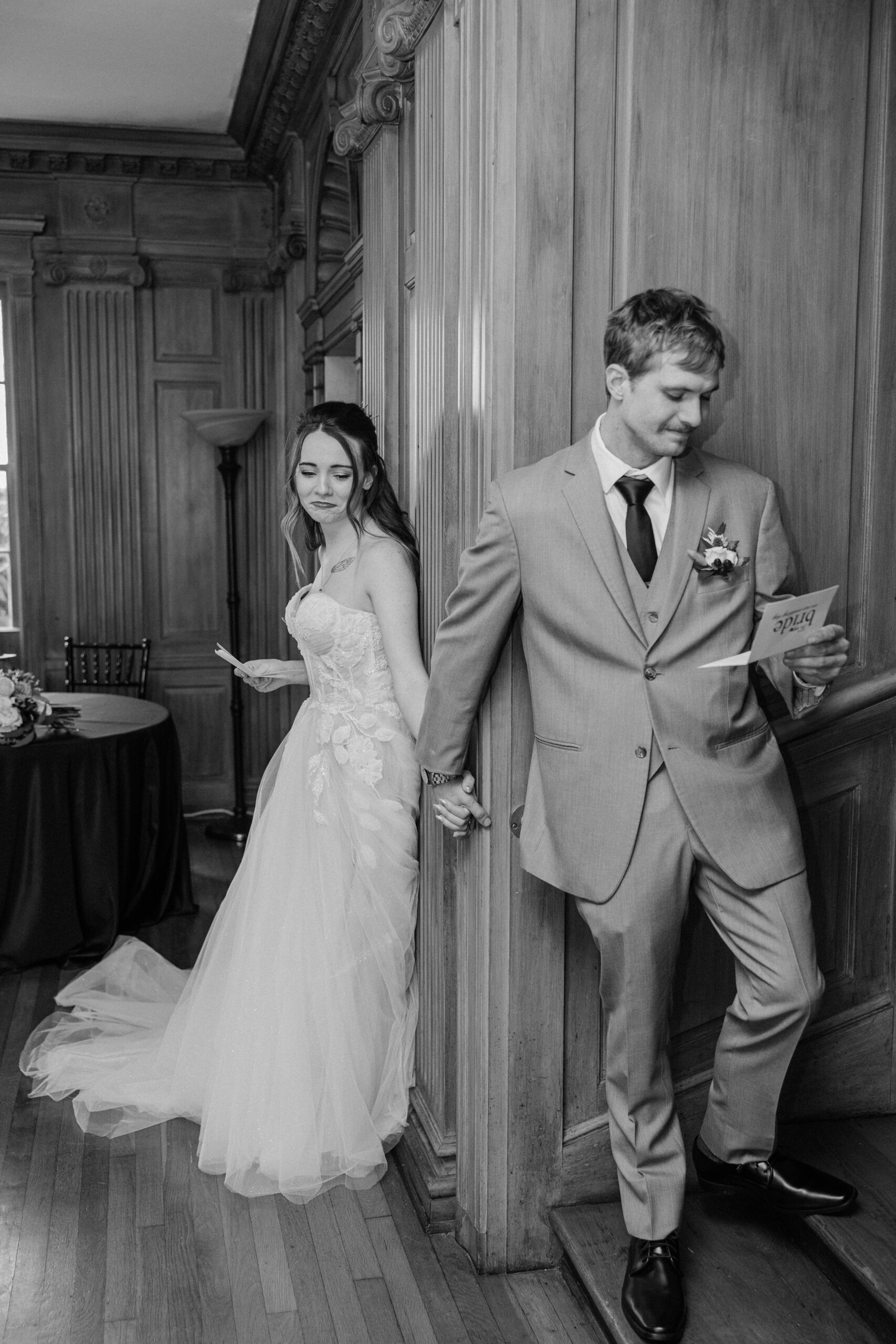 A bride and groom hold hands and read notes to each other during their first touch at The Finch House