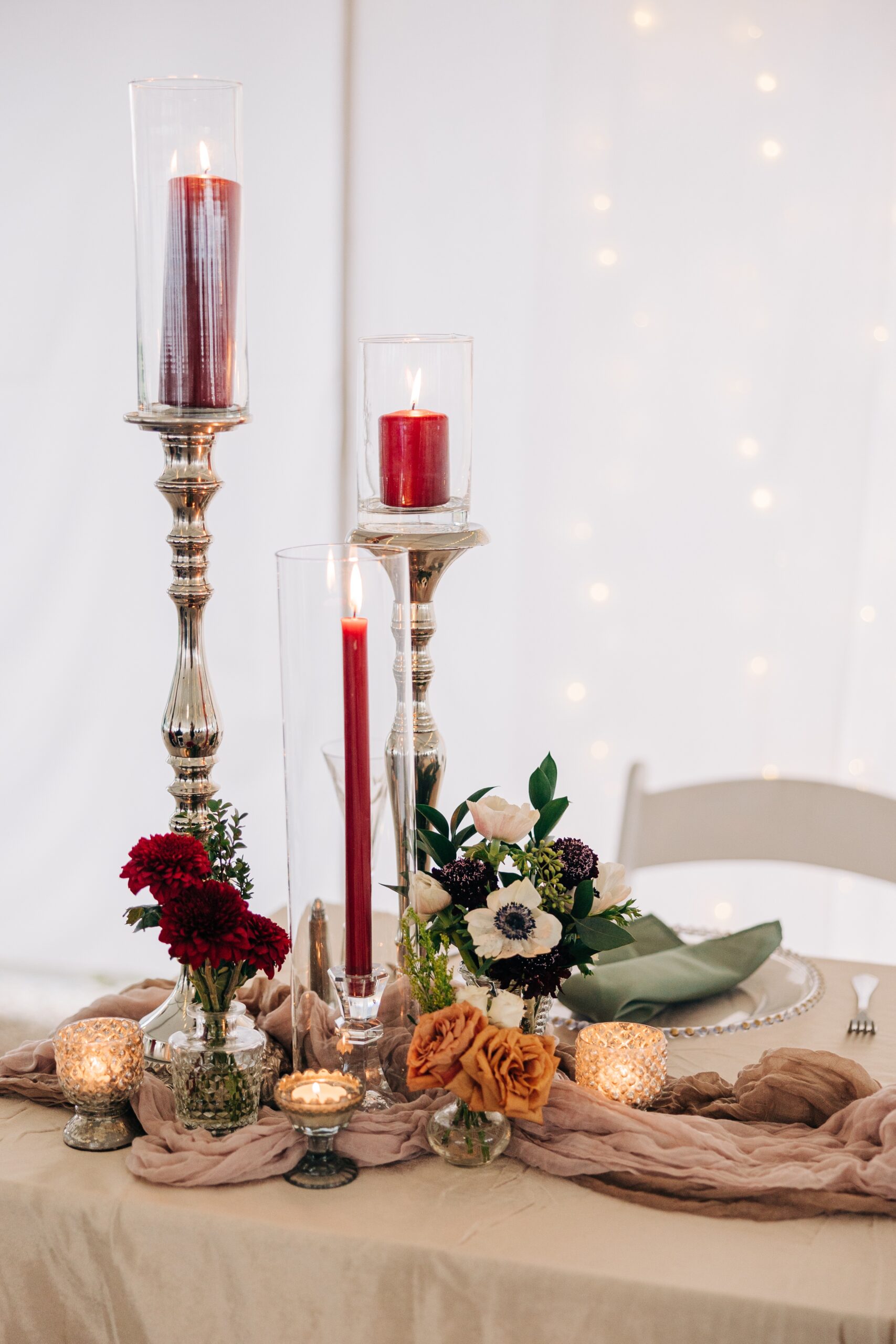 Details of a head table set up for a wedding reception at The Finch House with red candles