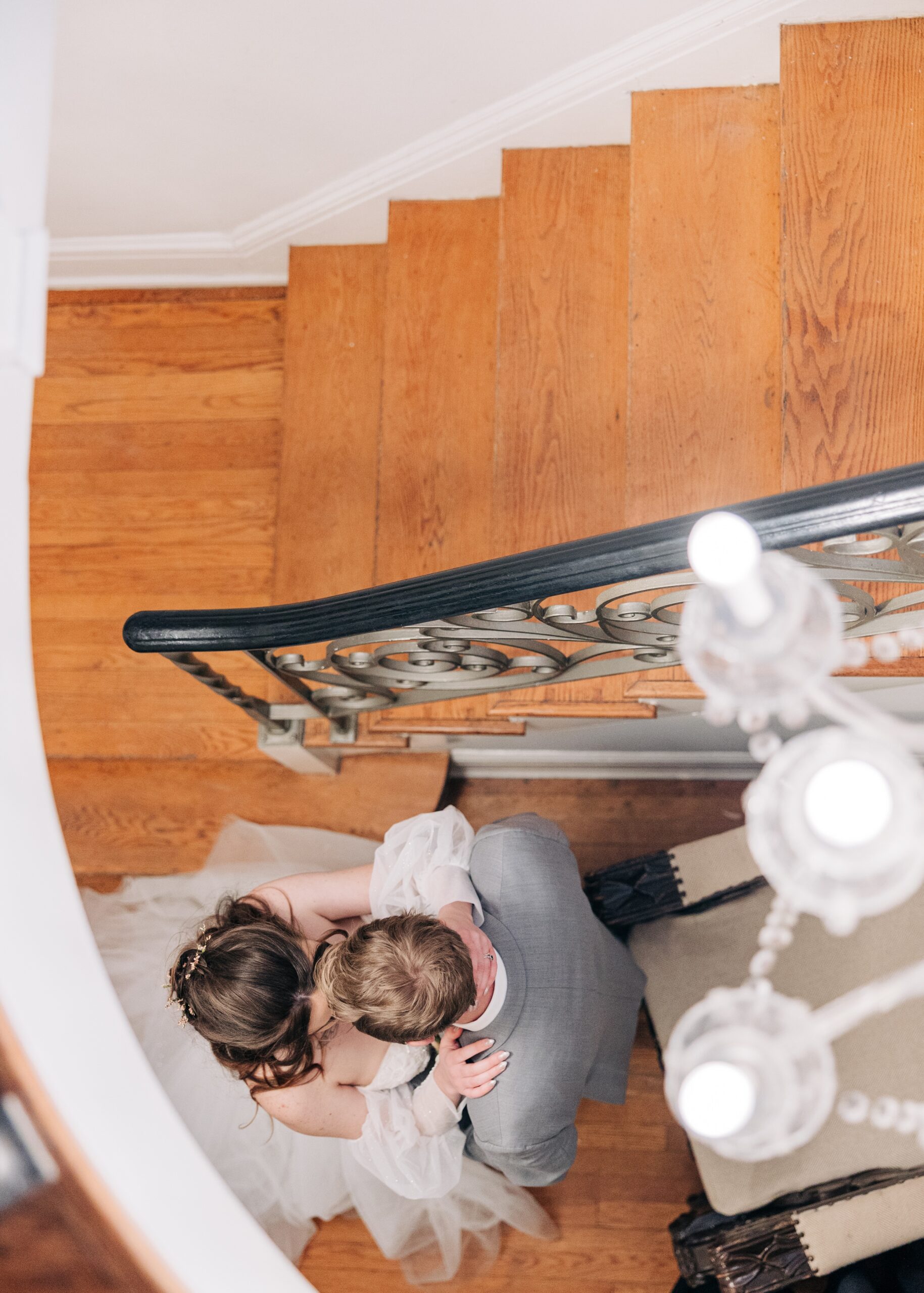 A look down at newlyweds kissing in the stairwell at The Finch House