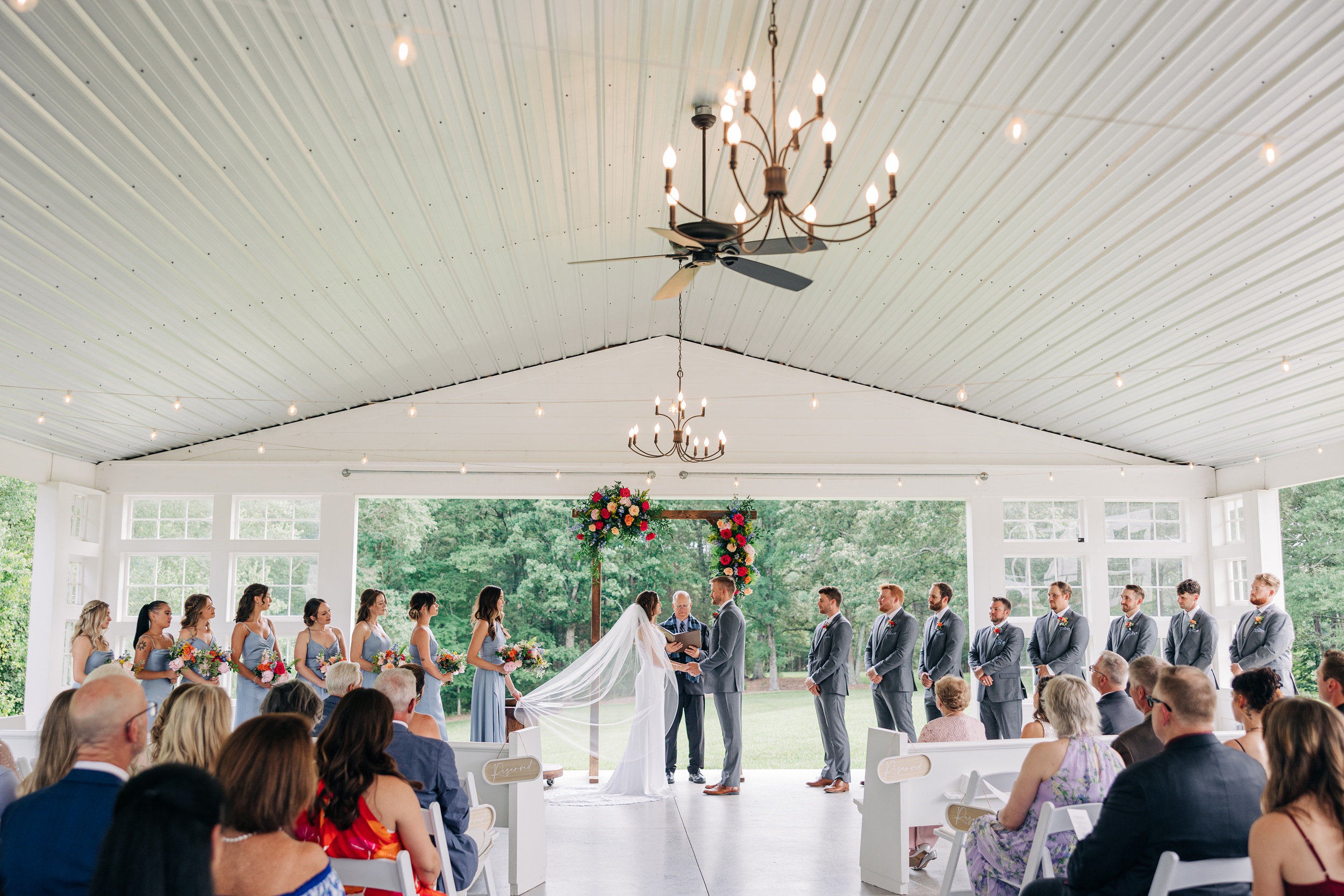 A bride and groom stand at the altar during their ceremony at The Ivory Barn