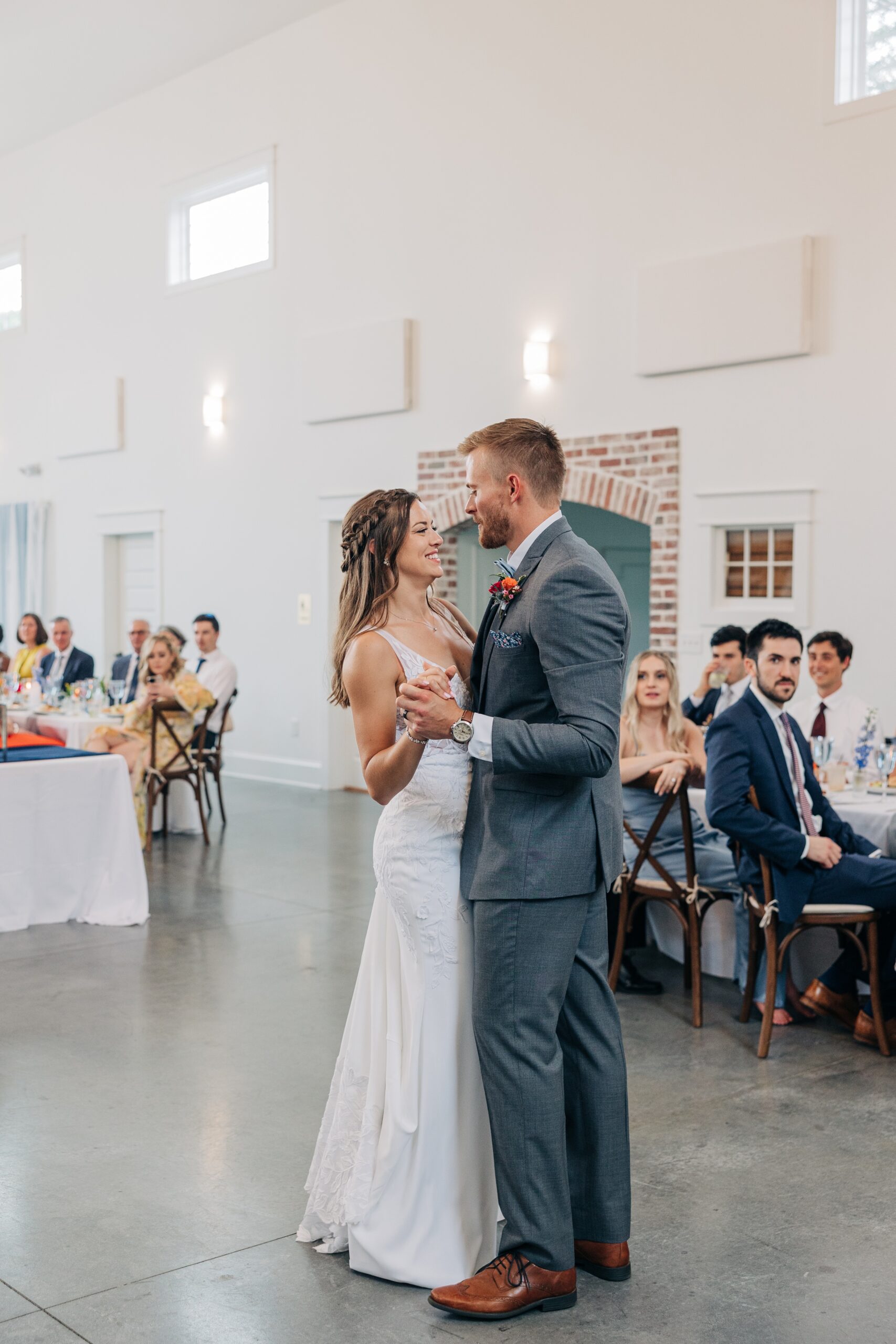 Newlyweds dance for the first time as guests watch atThe Ivory Barn