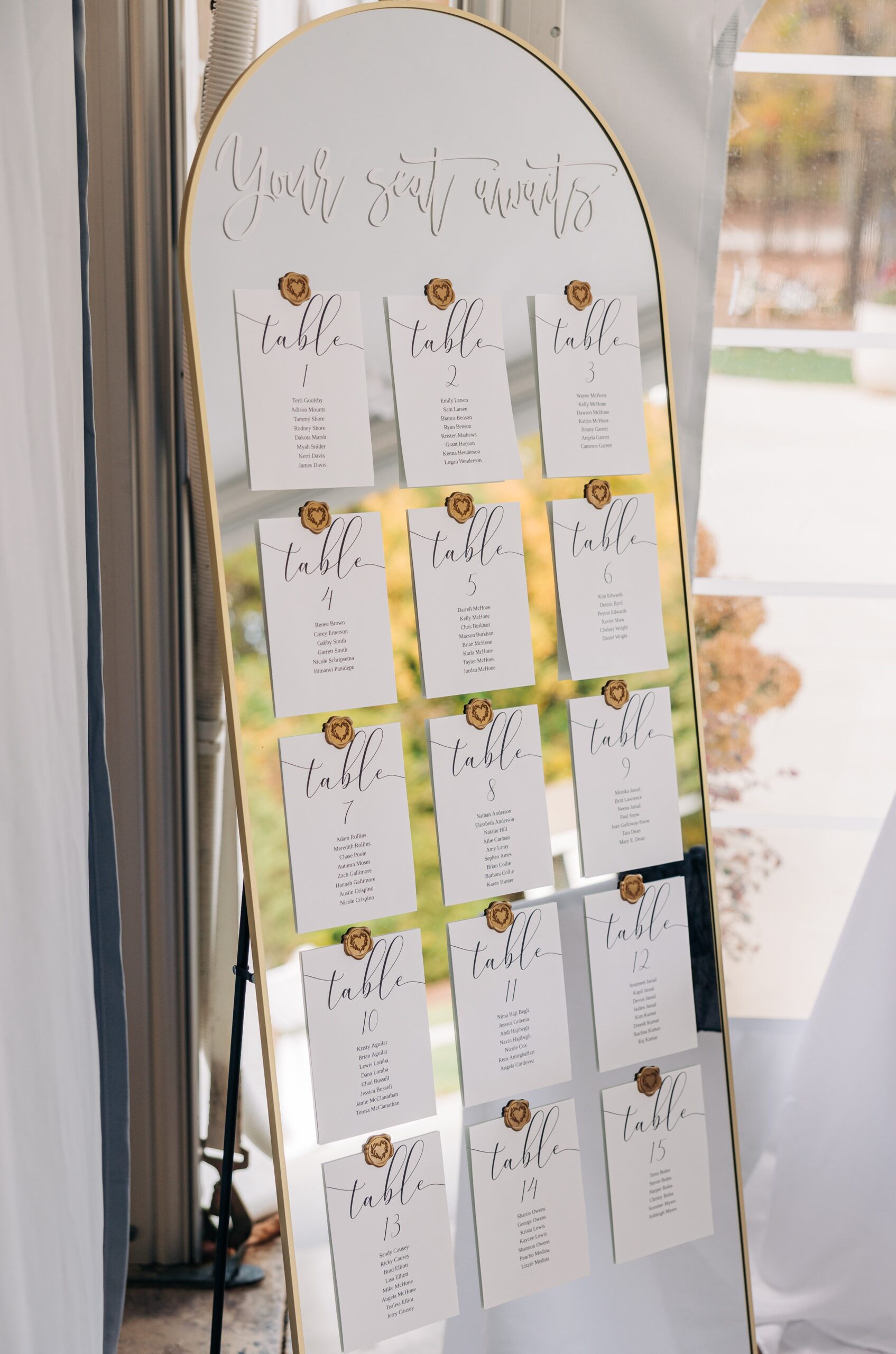 Details of a wedding reception seating chart on a mirror