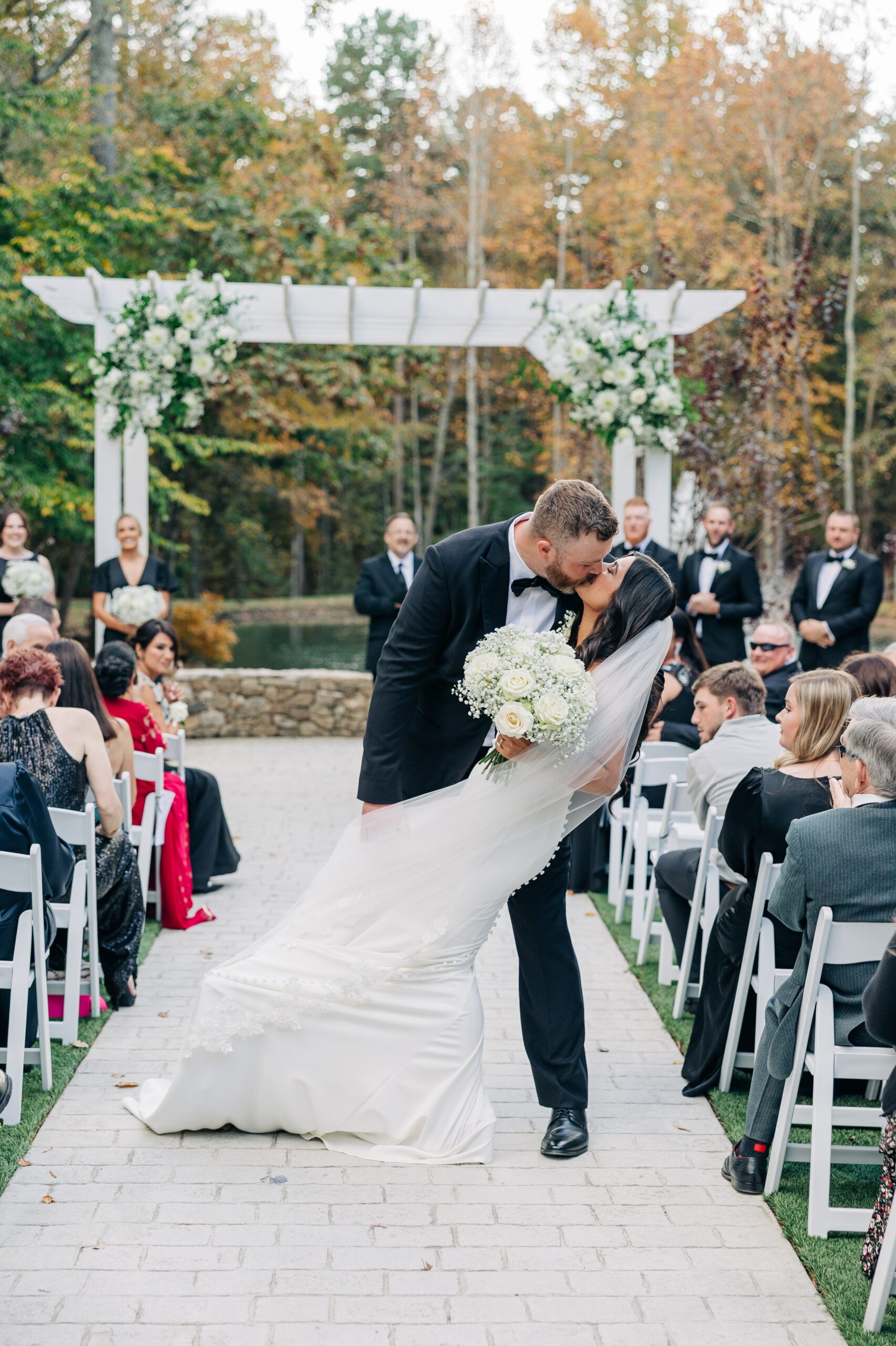 Newlyweds dip and kiss in the aisle while exiting their covington gardens ceremony