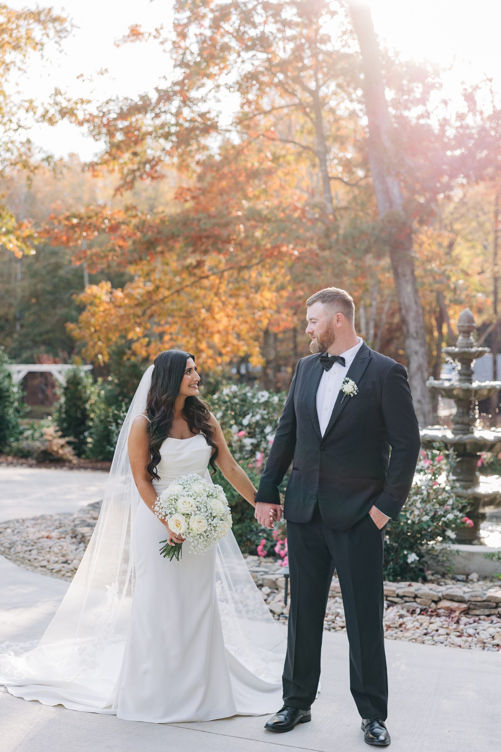 A bride and groom hold hands while exploring the gardens of covington gardens