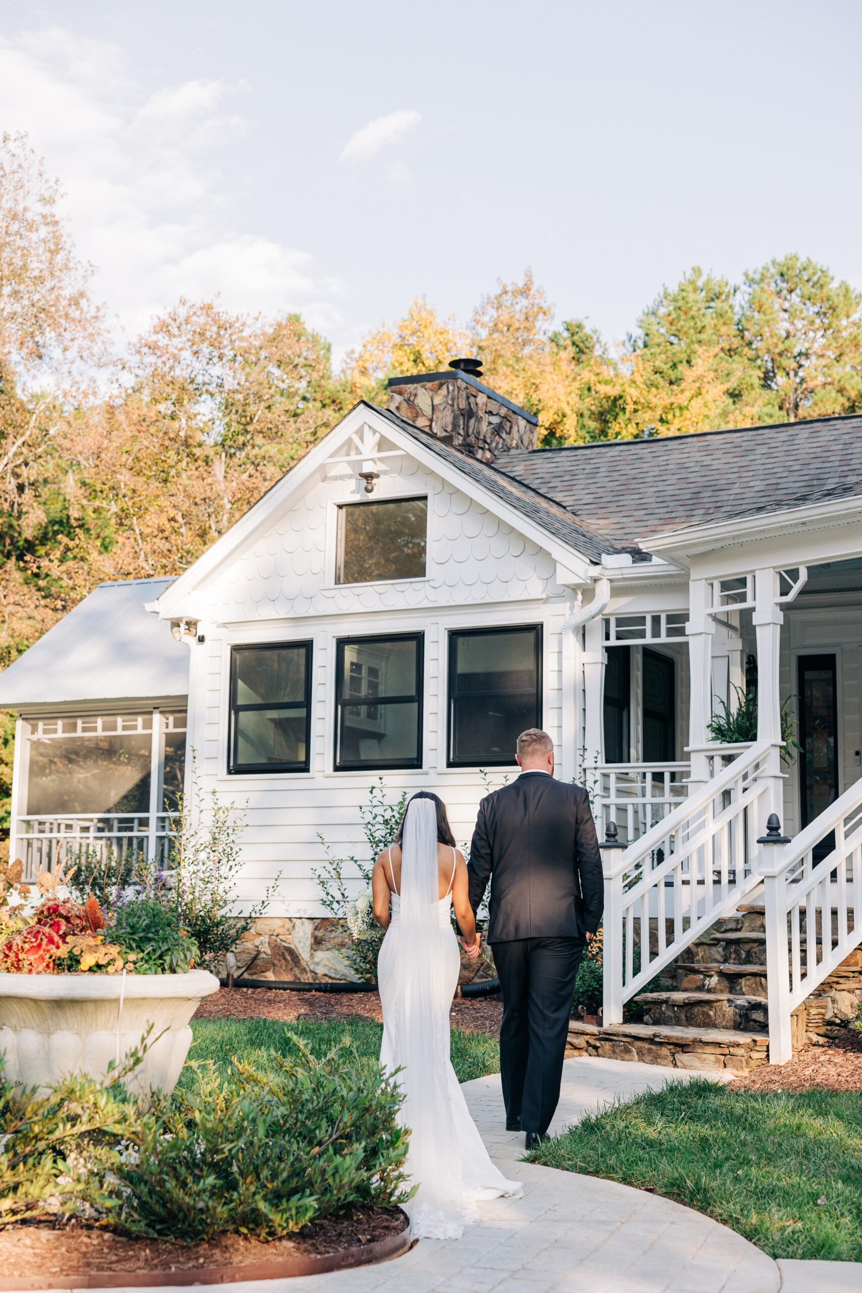 A bride and groom walk up to the porch holding hands at covington gardens