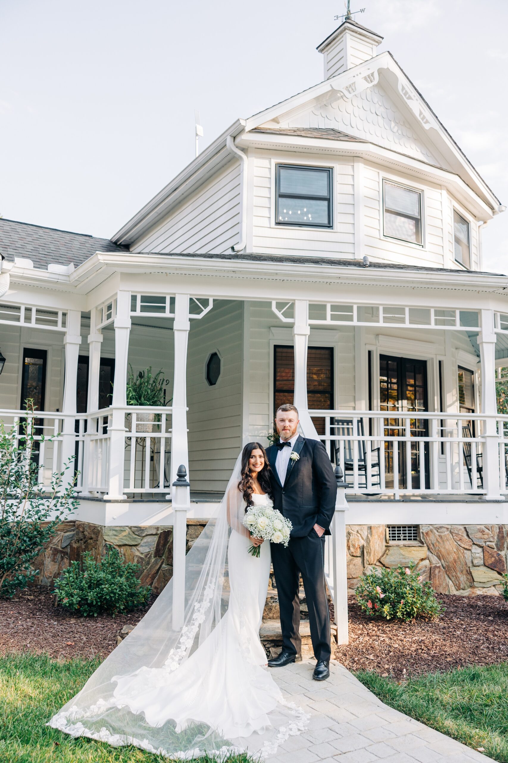 A bride and groom stand together smiling outside the historic covington gardens wedding venue