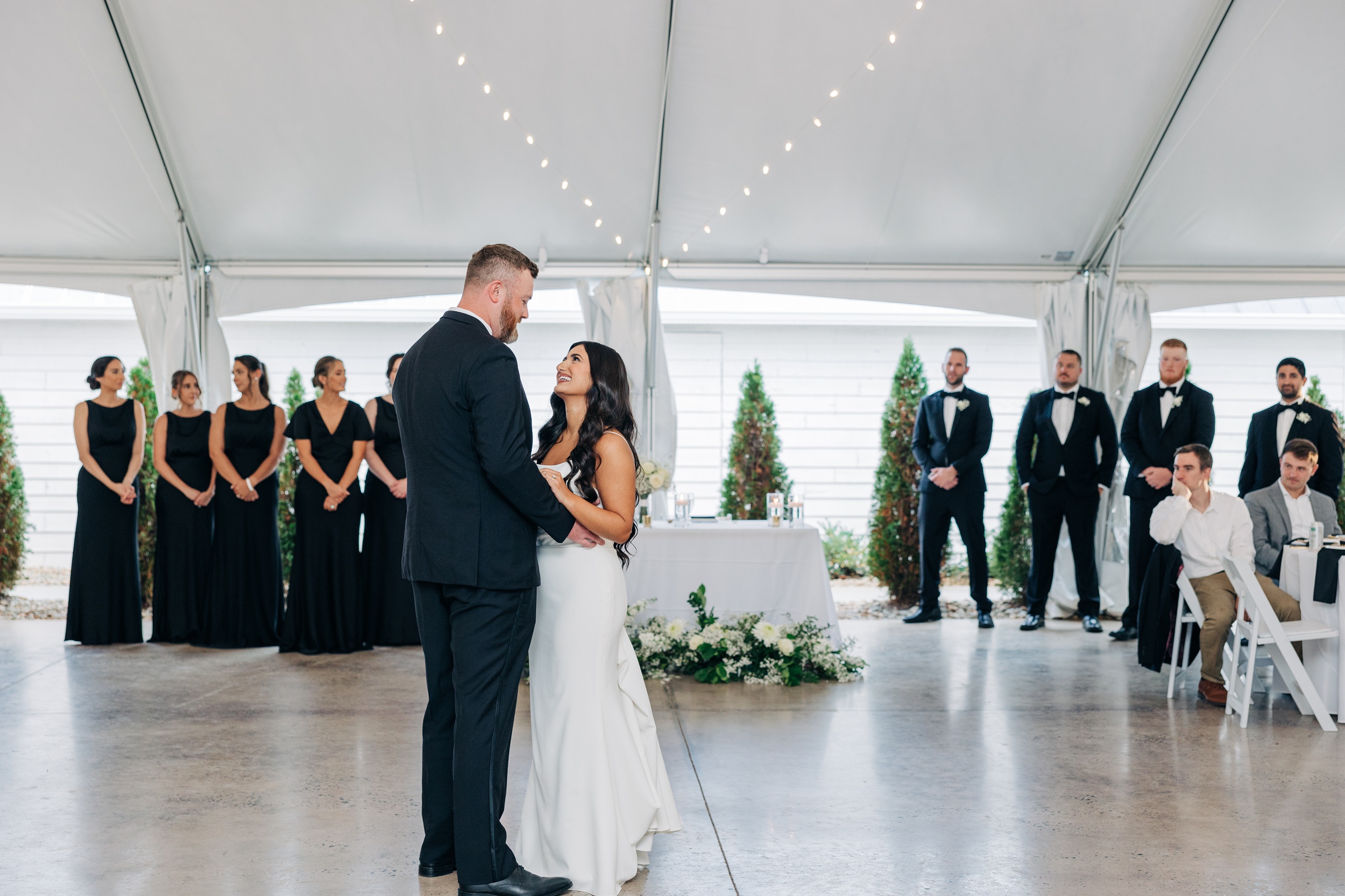 A bride and groom dance under the tent at their covington gardens wedding