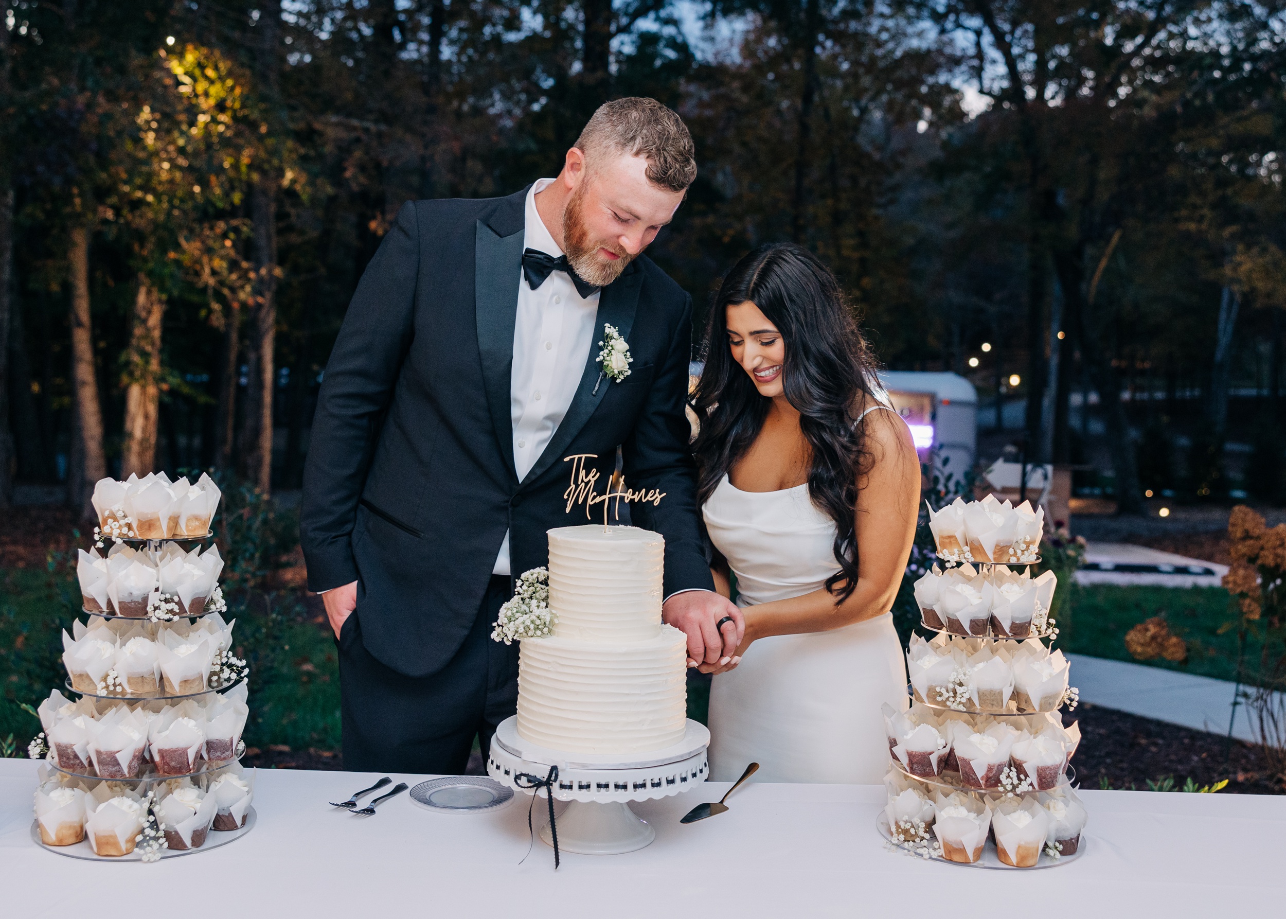 Newlyweds cut their 2 tier cake at their outdoor reception