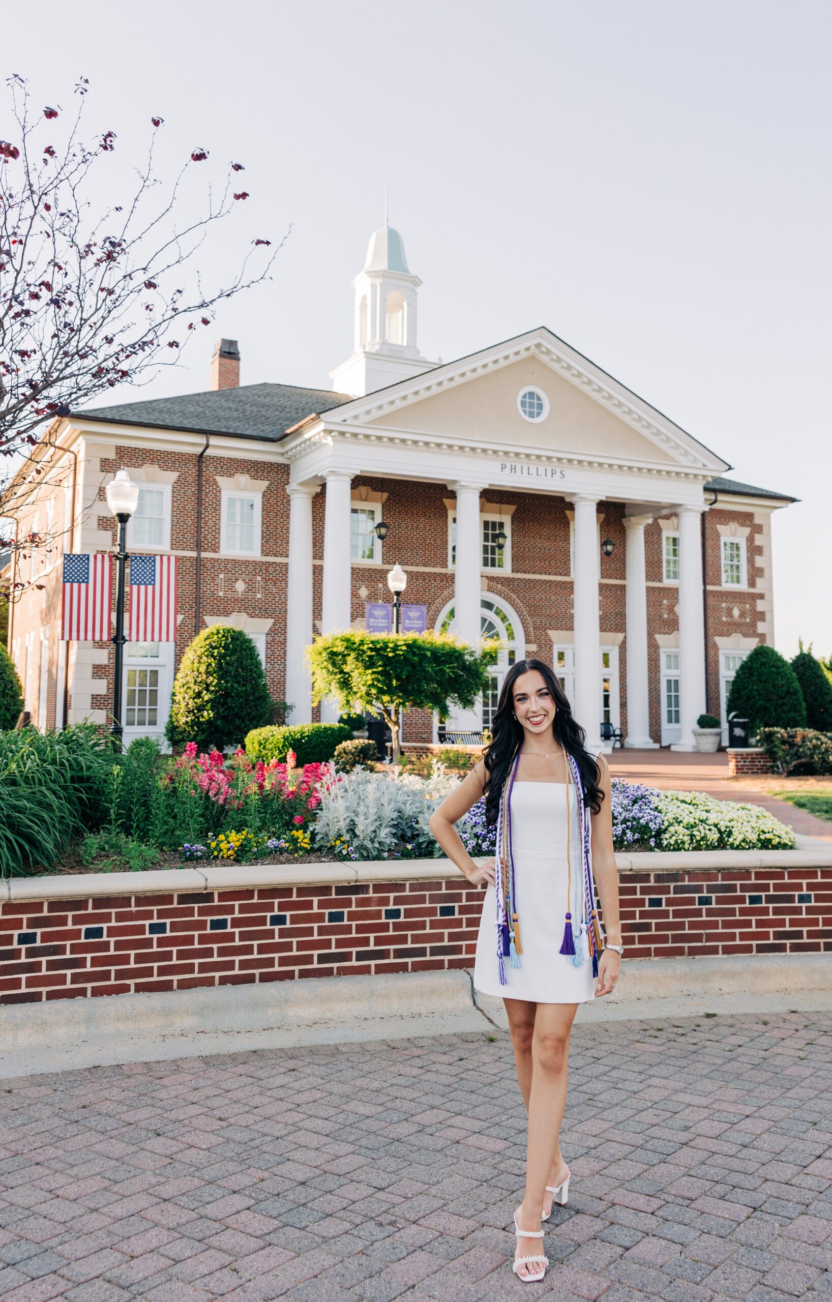 A happy grad stands with a hand on her hip for her high point university graduation photographer