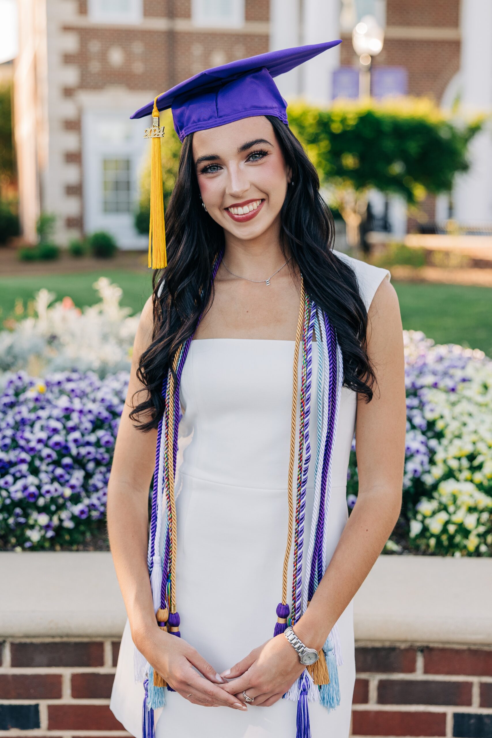 An image from a high point university graduation photographer of a woman smiling in her purple cap and cords