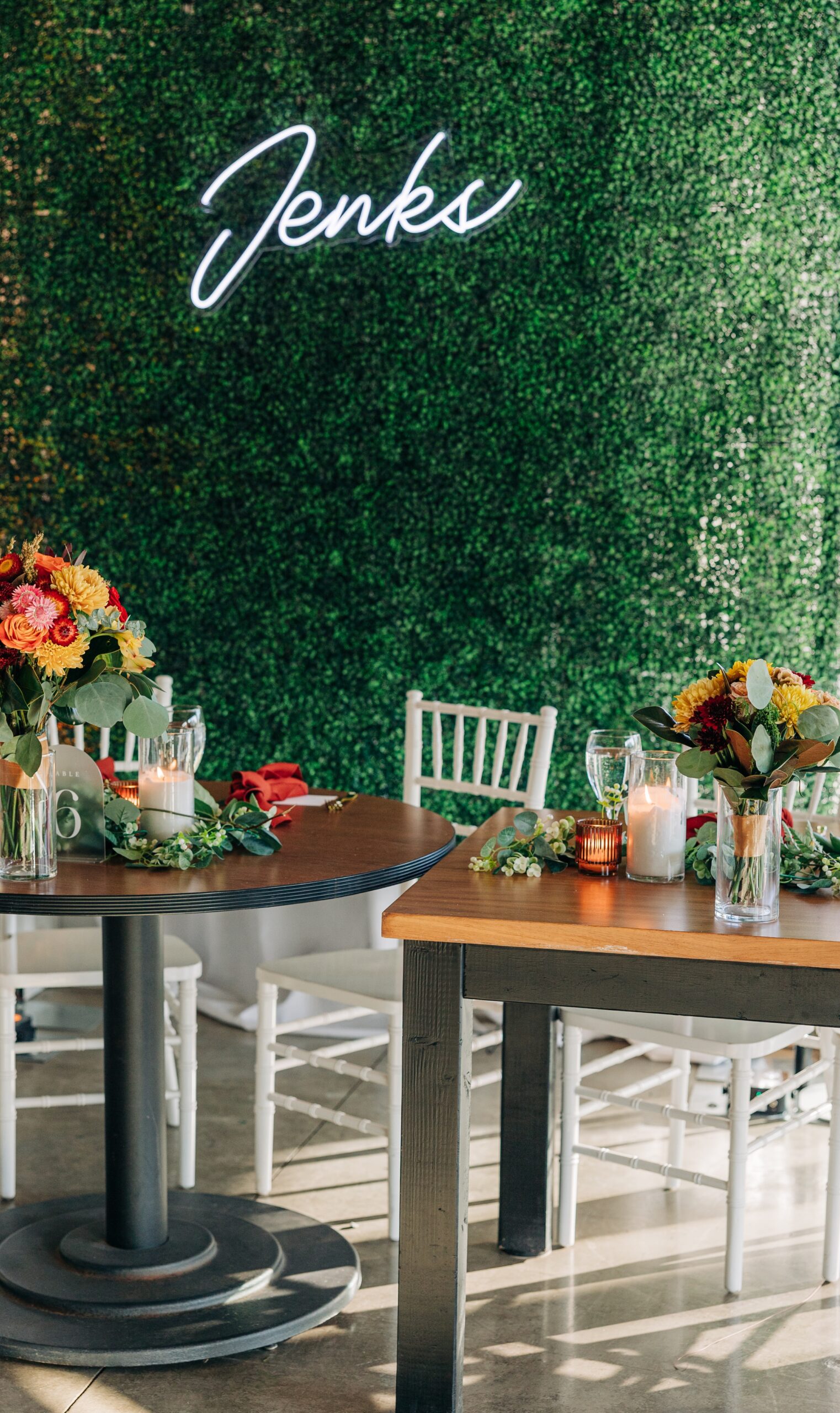 A look at a splendor pond flower farm wedding reception head table with a custom neon sign on a green wall