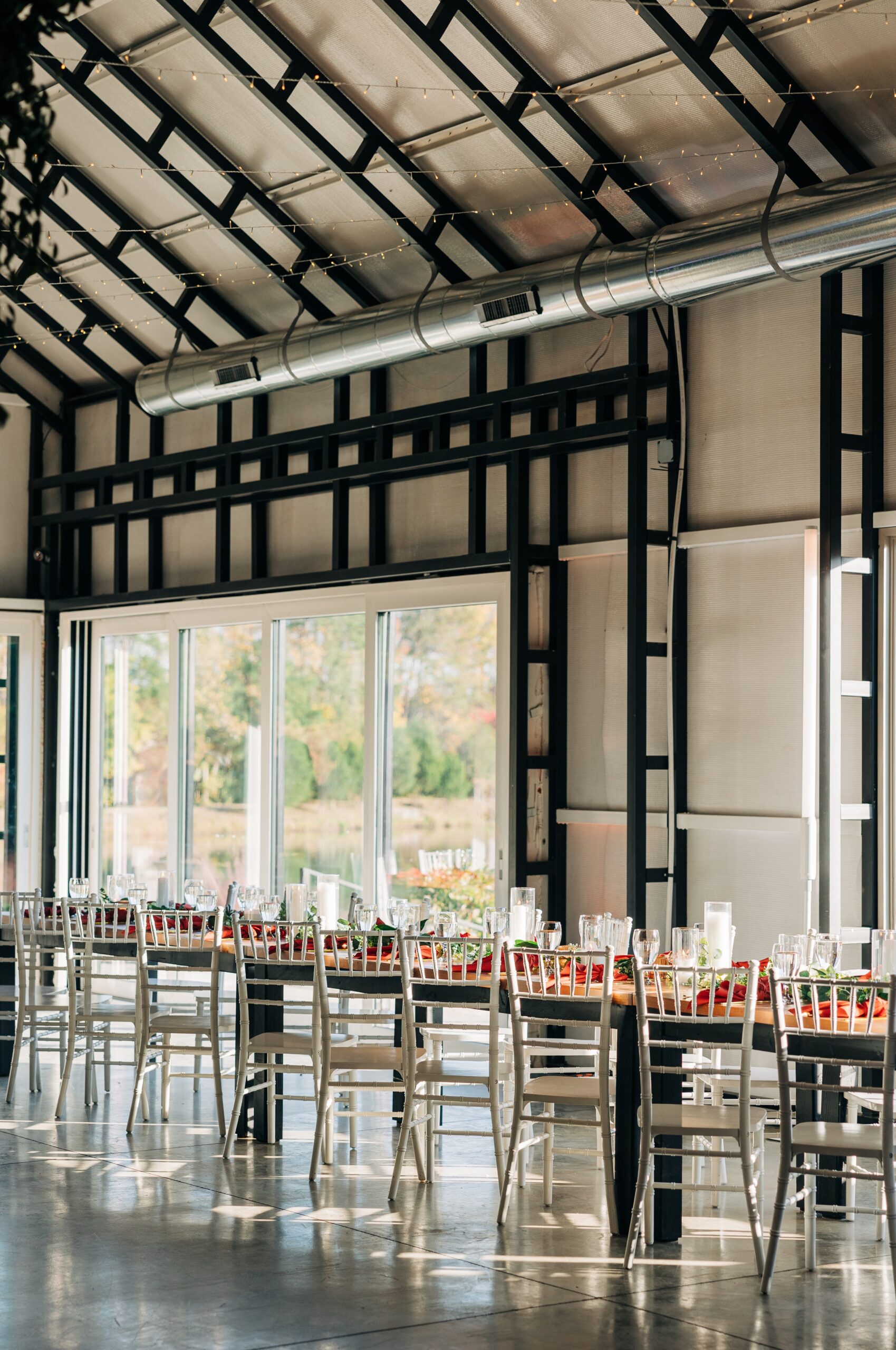 Details of a reception table set up with red linen and white chairs