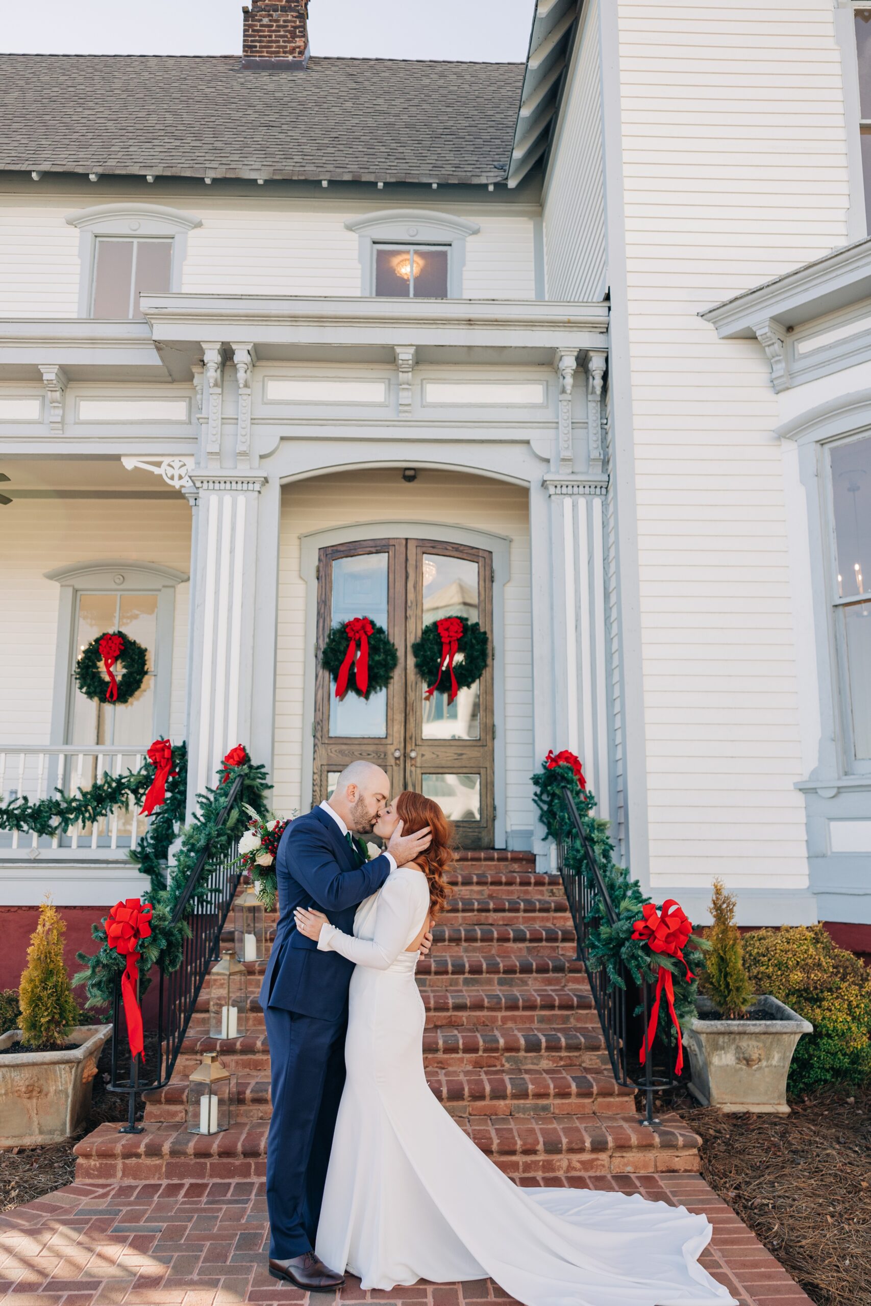 Newlyweds kiss at the front door of the crest winston-salem wedding venue