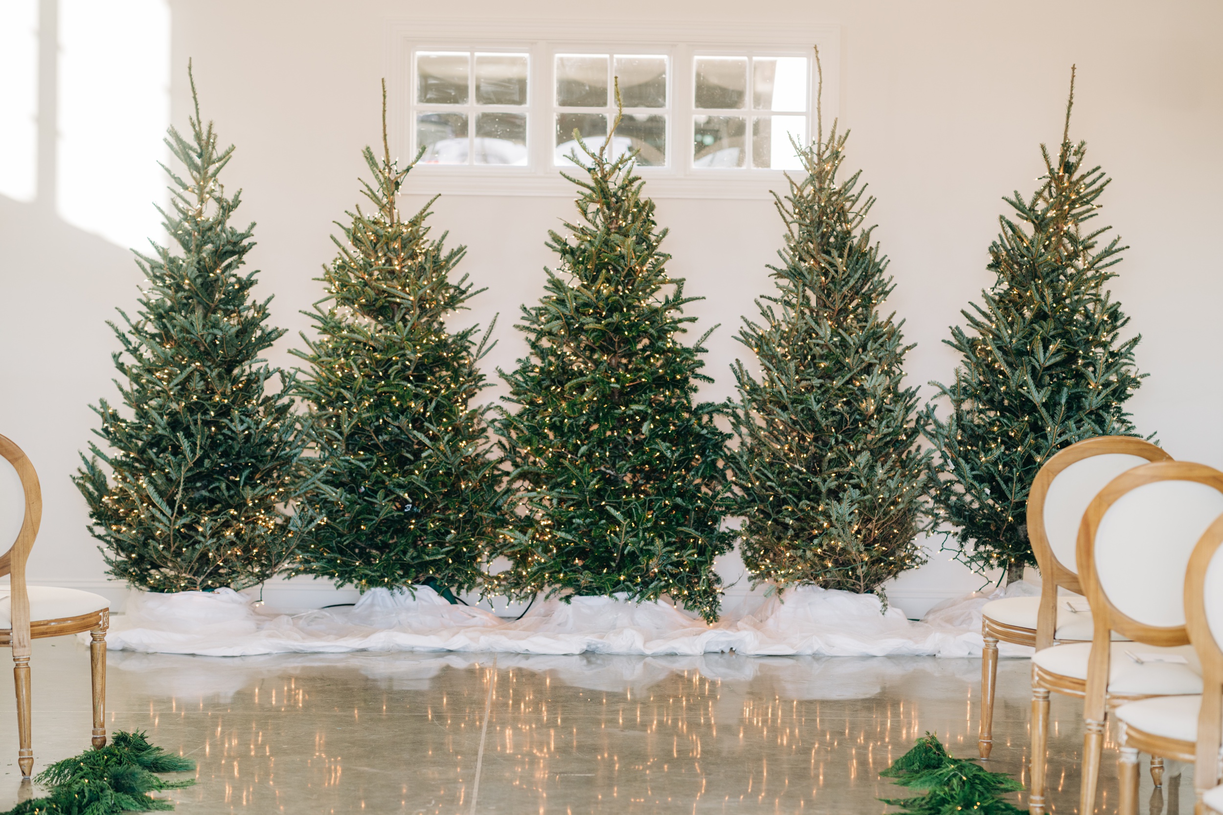 Details of christmas trees serving as backdrop for wedding altar