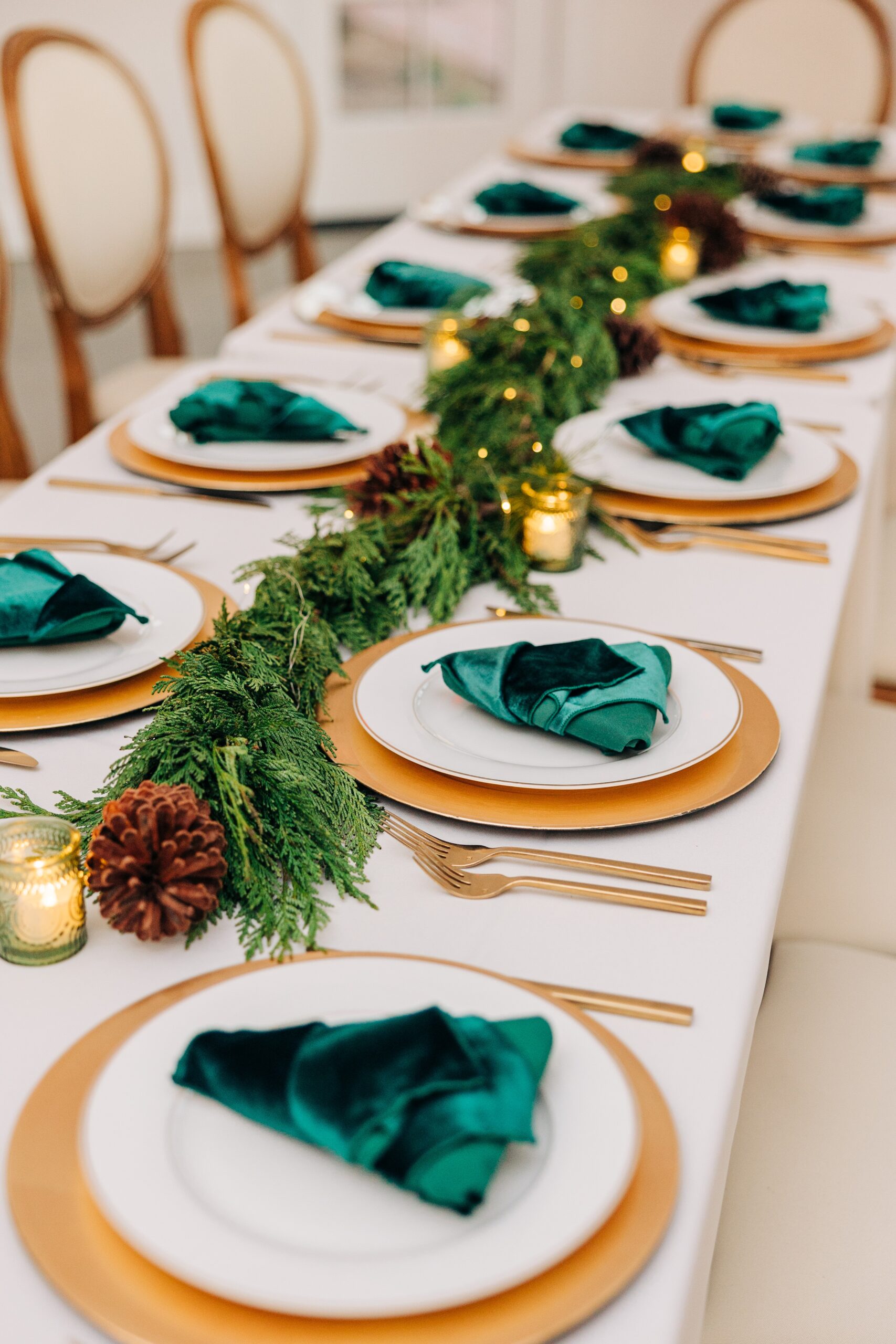 Details of a wedding reception table set up with gold chargers and utensils and christmas wreathe at the crest winston-salem