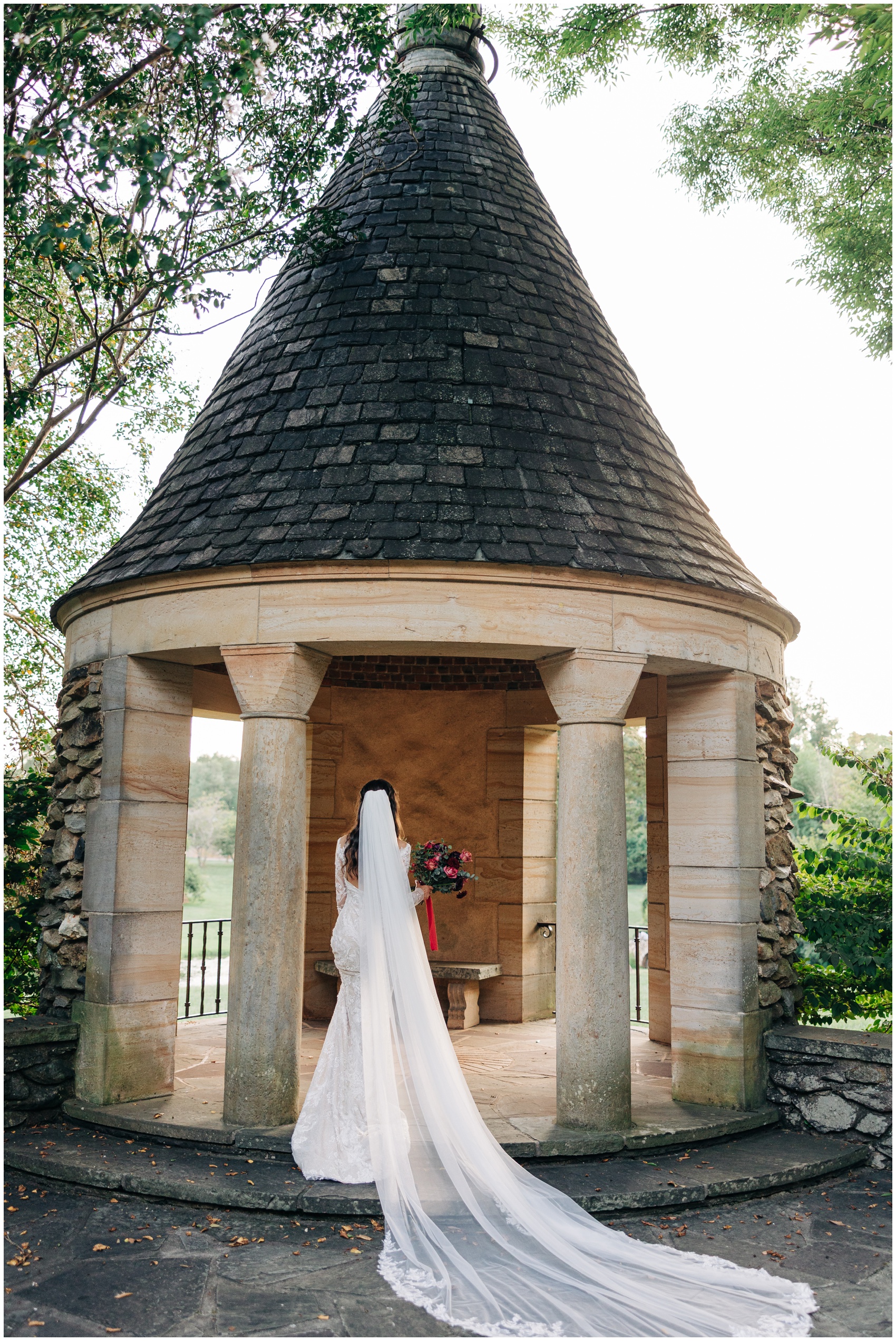 A bride walks into a gazebo holding her bouquet