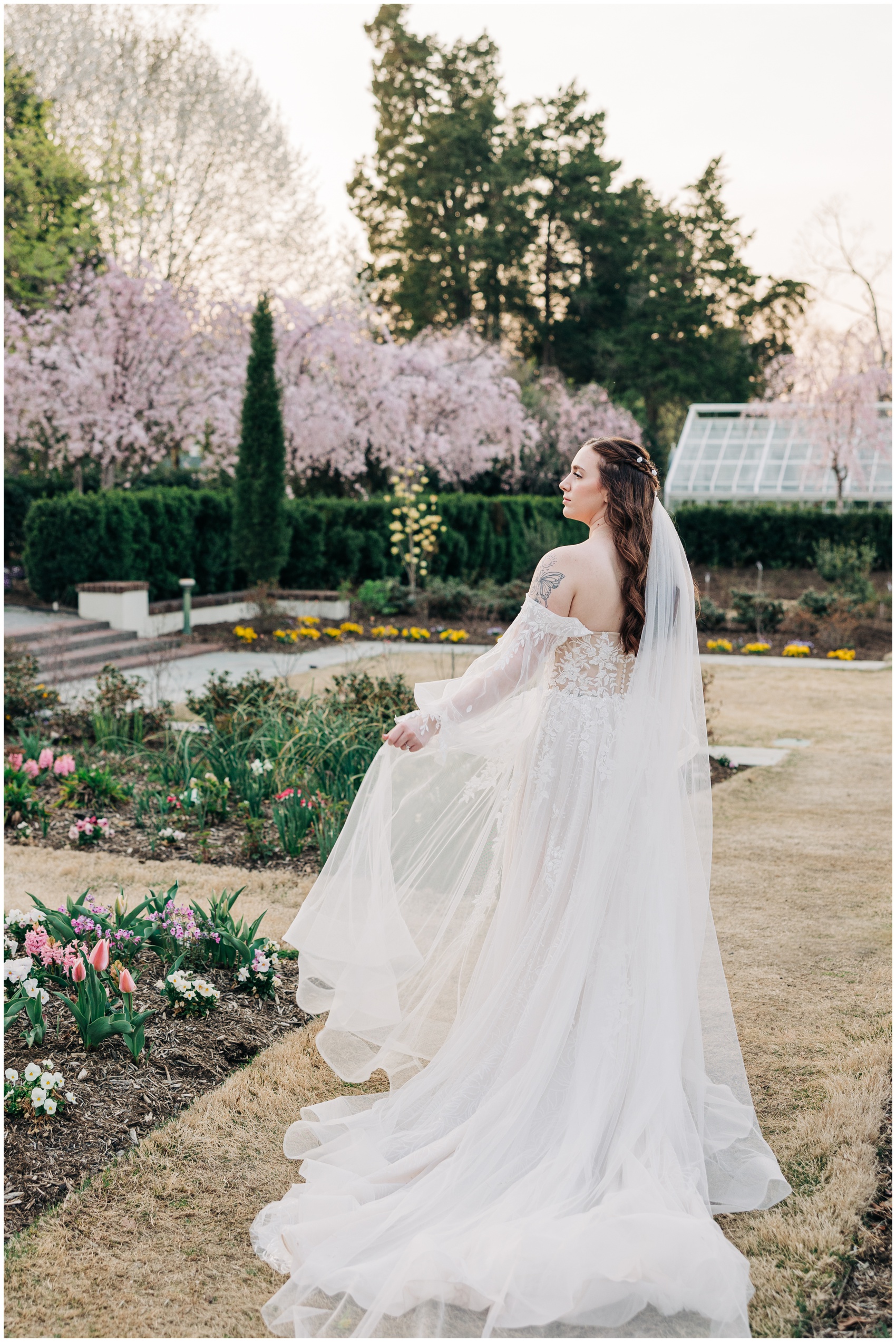 A bride explore Reynolda Gardens with flowers and cherry blossoms in bloom at one of the beautiful Winston Salem Wedding Venues