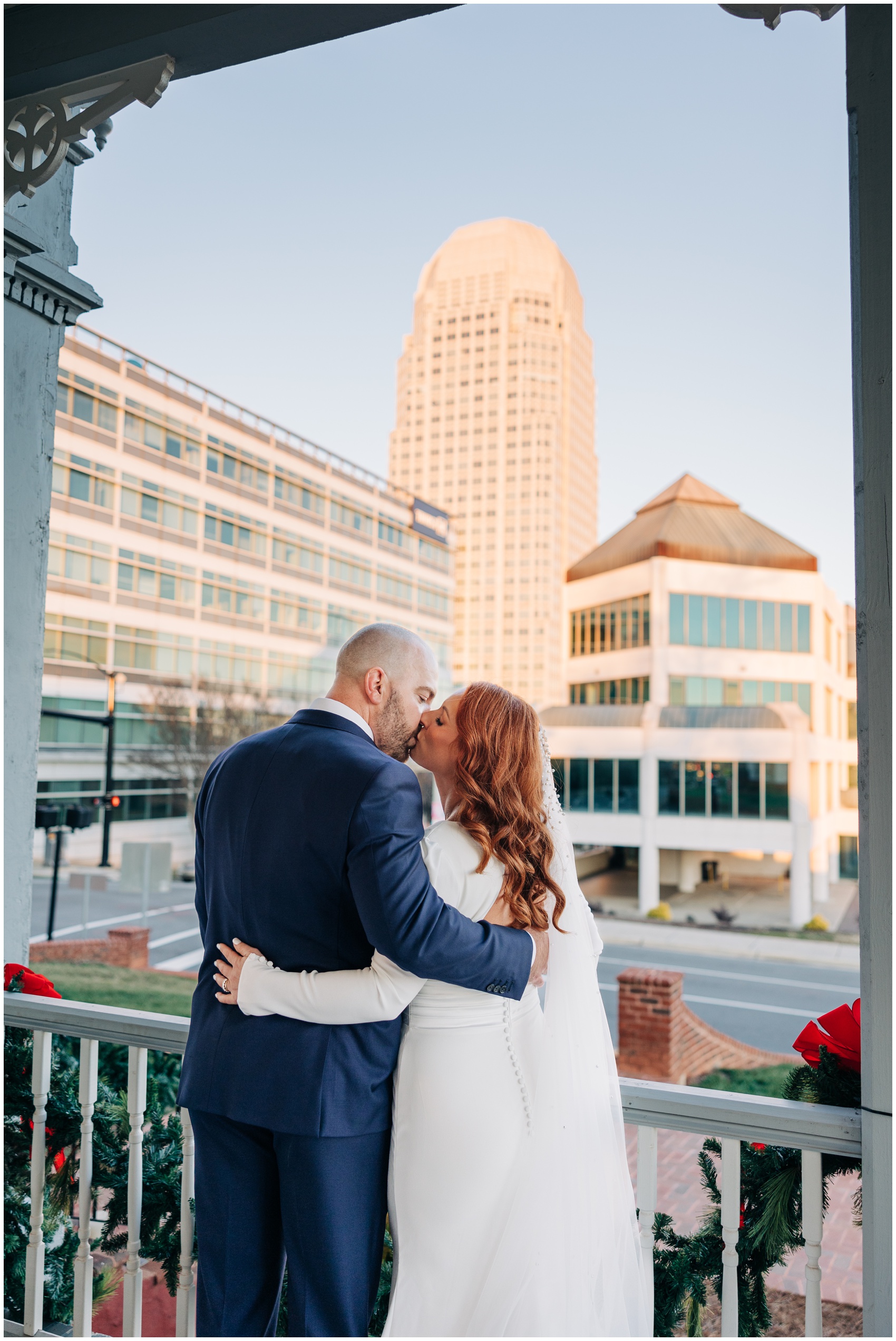 A bride and groom kiss on the front porch of one of the Winston Salem Wedding Venues
