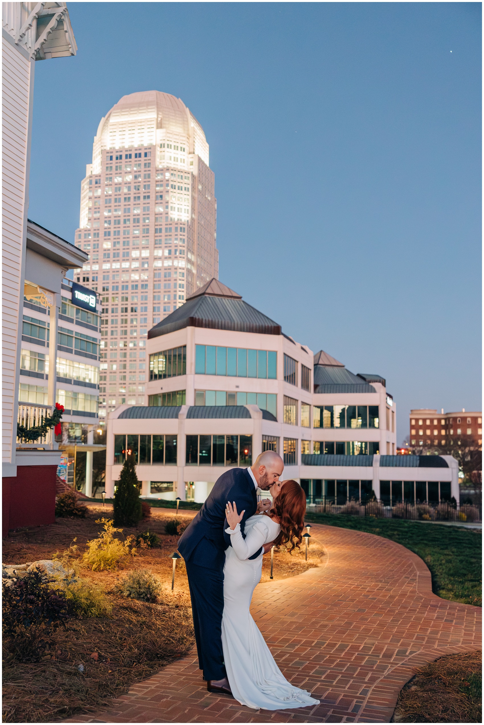 Newlyweds kiss under the skying on a brick path after sunset at one of the downtown Winston Salem Wedding Venues
